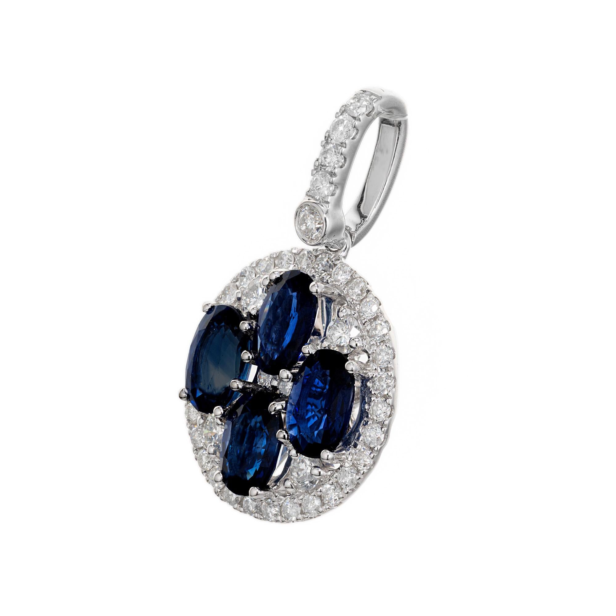 Sapphire and diamond pendant. Four deep blue oval sapphires set in an 18k white gold circle setting. The sapphires are enhanced by a halo of round cut white diamonds. The bezel is also accented with round cu diamonds. The GIA randomly tested one