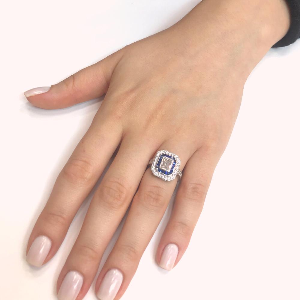 This unisex friendly cocktail ring holds an emerald cut white diamond 1.01 ct center stone that is GIA Certified.
It is accented within a frame of Ceylon blue French cut sapphires 0.28 ct and round diamonds 0.32 ct.
Platinum 950 metal.
Width: 1.3