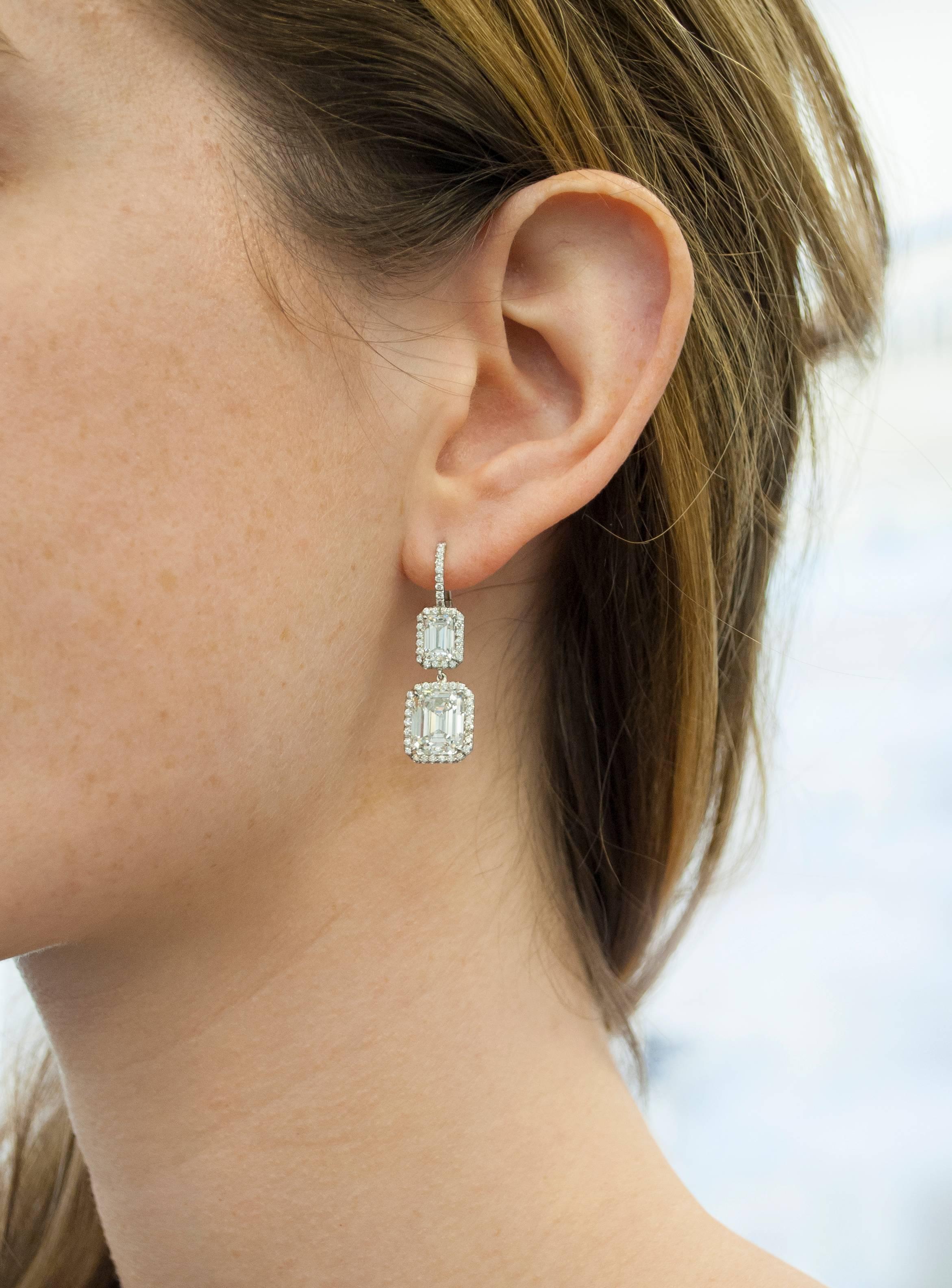 Each drop earring in this breathtaking pair signed by Harry Winston features two emerald cut diamonds sitting on top of each other, surrounded by pave diamond frames. Together, the two emerald cuts sitting atop weigh approximately 2.50 carat total