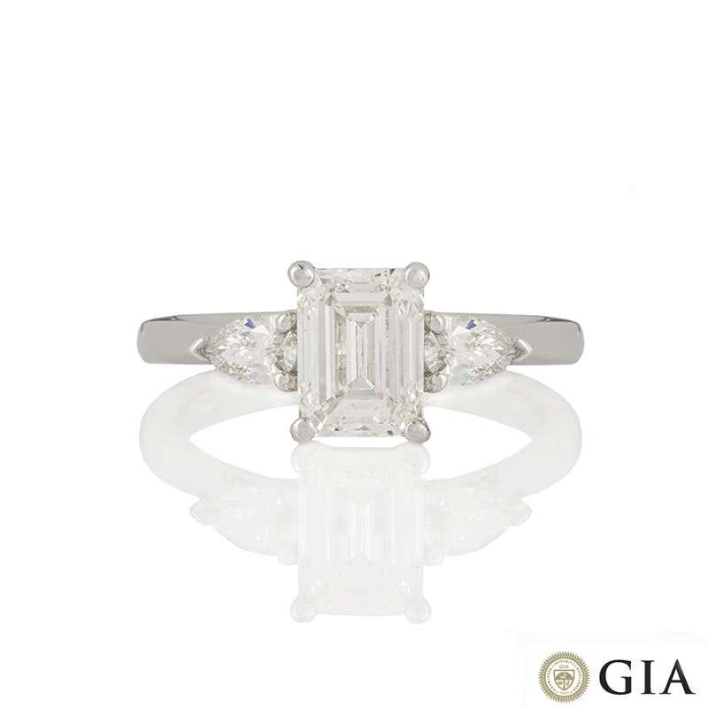 An 18k white gold diamond ring. The ring is set to the centre with a 1.17ct emerald cut diamond, G colour and VVS2 in clarity set within a classic four claw mount. Complementing the central stone are single pear cut diamonds set each side totalling