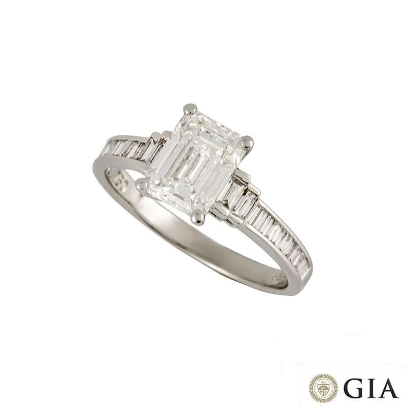 An 18k white gold diamond ring. The ring is set to the centre with a 1.51ct emerald cut diamond, F colour and VVS2 in clarity set within a classic four claw mount. The central diamond is accentuated by step cut baguette diamond side stones leading