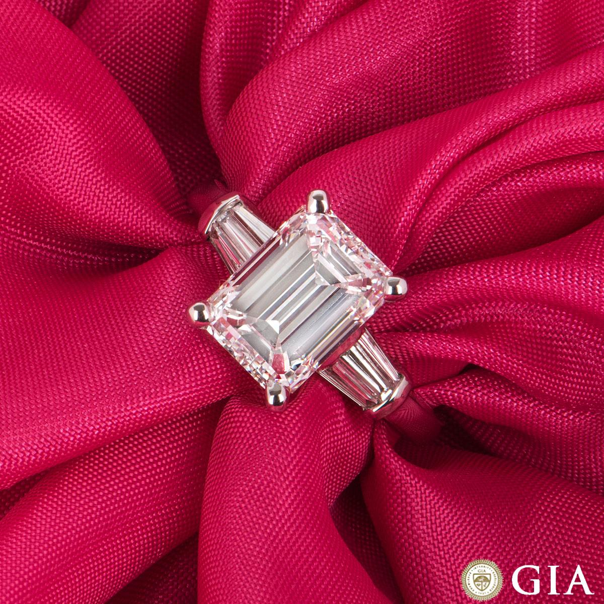 A stunning white gold emerald cut diamond ring. The emerald cut diamond is set within a four claw setting and weighs 3.02ct, G colour and VVS2 in clarity. The central diamond is flanked on either side with 3 tapered baguette cut diamonds, totalling