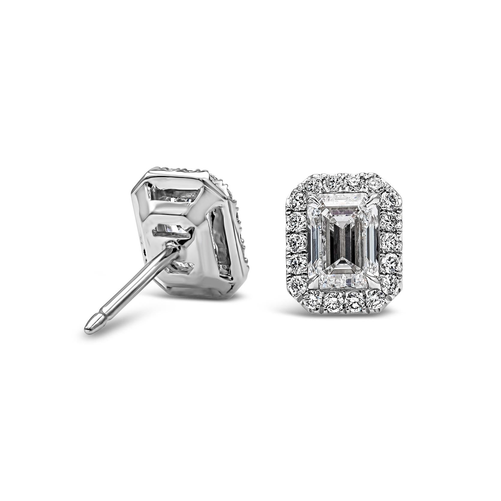 A fashionable pair of stud earrings showcasing two emerald cut diamonds weighing 1.41 carats total, certified by GIA as D-F Color, SI1 in Clarity. Each emerald cut diamond is surrounded by a single row of round diamonds 0.27 carats total, F Color