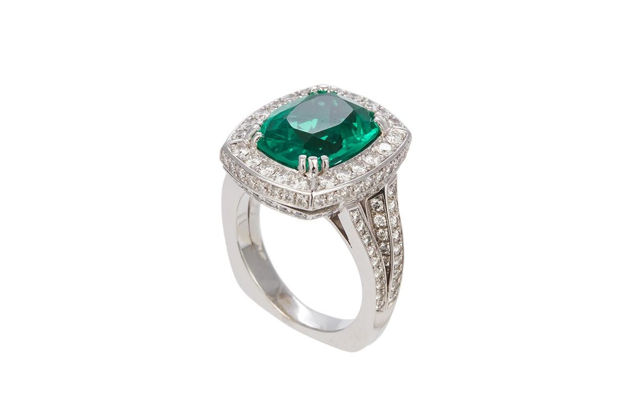 We are pleased to offer this GIA Certified Emerald & Diamond 18k White Gold Cocktail Fashion Ring. This stunning ring feature an estimated 5.70ct GIA certified cushion cut synthetic emerald accented by approximately 2.00ctw F-G/VS2-SI1 round