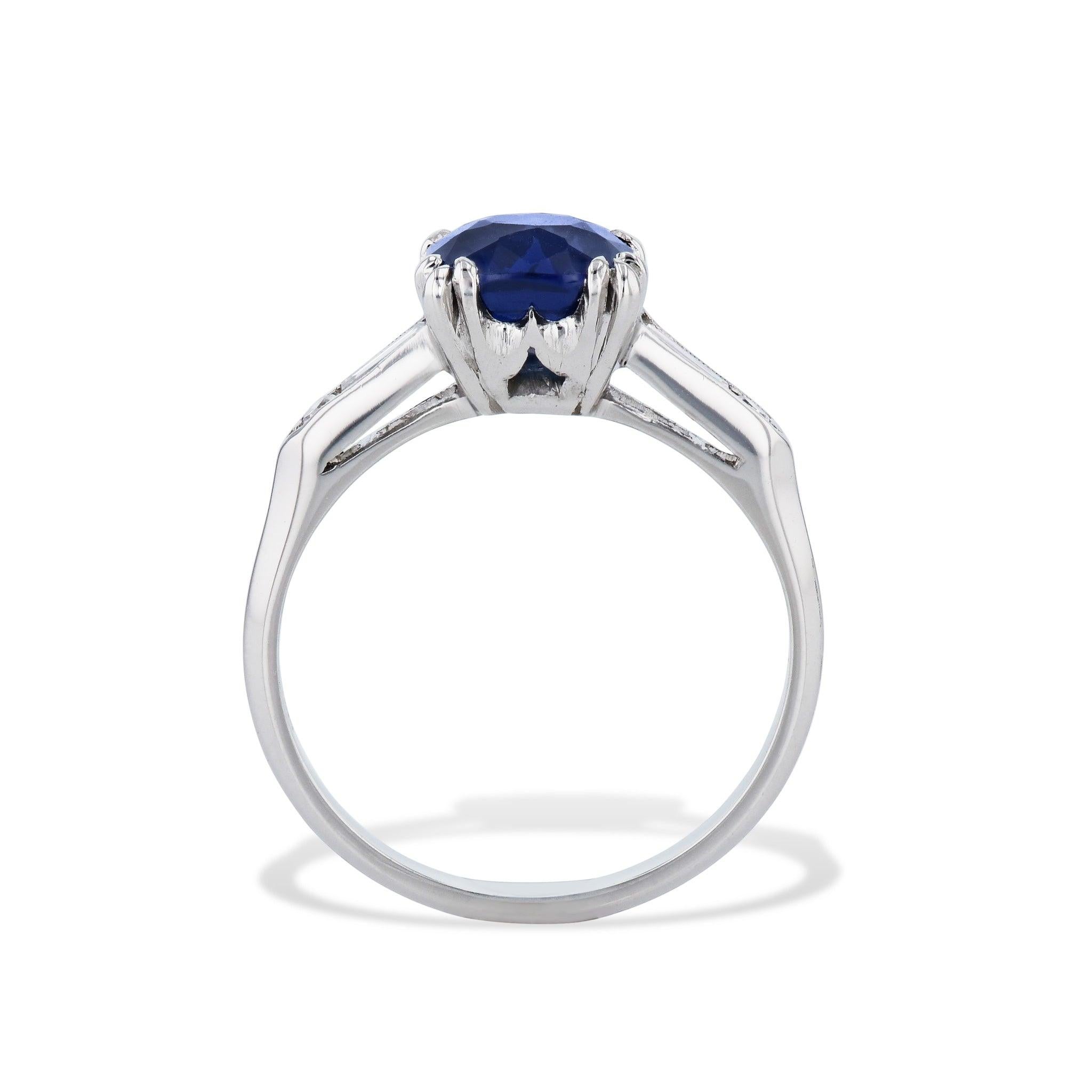 
This exquisite Cushion Cut Blue Sapphire and Diamond Platinum Ring is absolutely stunning. It is  from the 1940's and features a cushion cut, unheated Blue Sapphire with diamond baguettes on each side.

It is crafted in platinum.
The Blue Sapphire
