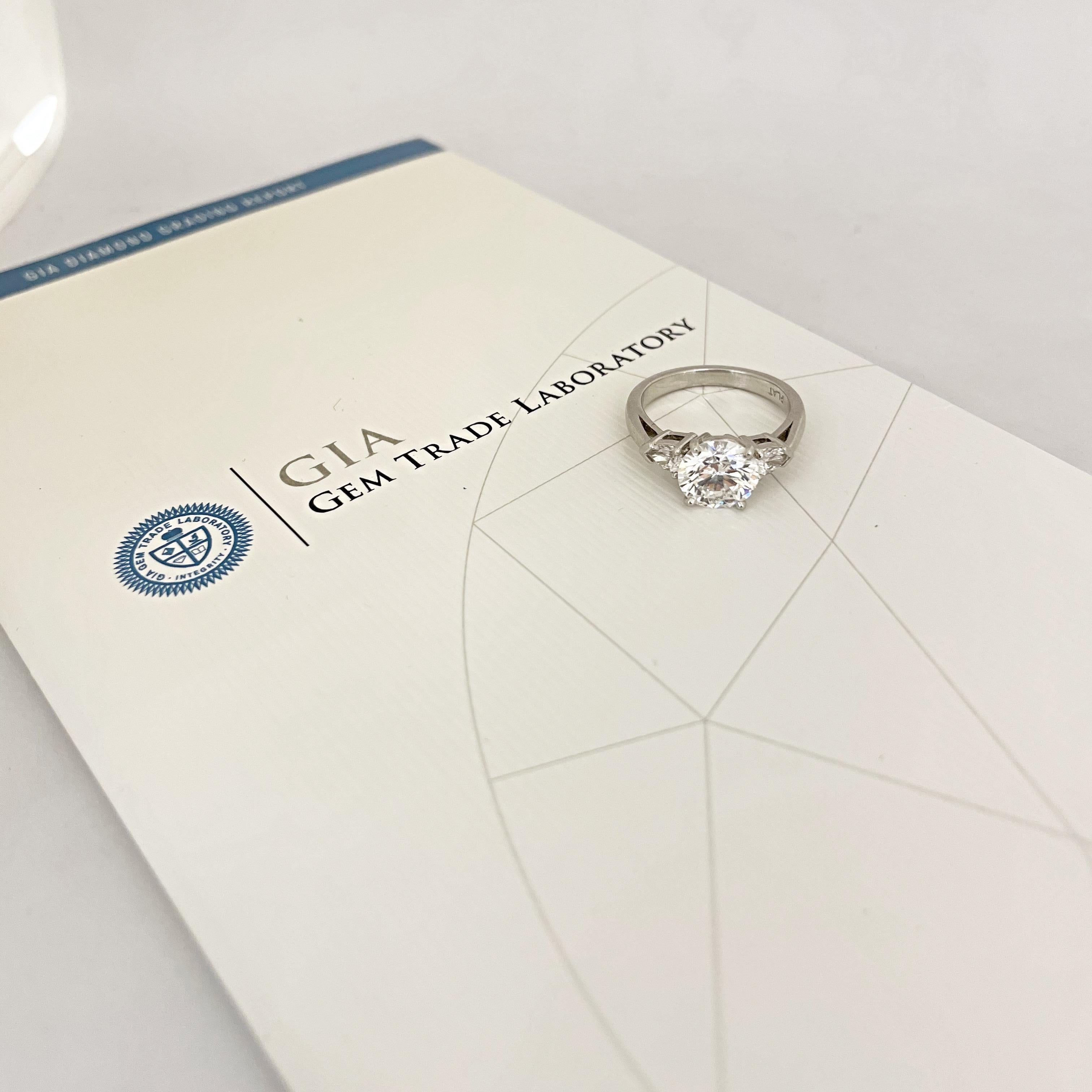 This stunning 2.07ct GIA certified Round Brilliant F color VS2 clarity center stone is hand set in platinum with pear shaped side stones. 
The pear shaped side stones are F color VS2 and weigh 0.38cts. 

Purchase includes complimentary ring sizing,