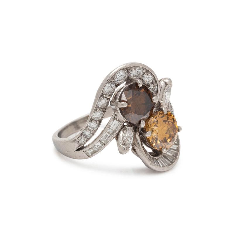 Este hermoso anillo presenta dos diamantes marrones, un diamante redondo talla brillante de color amarillo anaranjado parduzco oscuro de fantasía, con un peso de 1,54 quilates, y un diamante redondo talla brillante de color marrón, con un peso