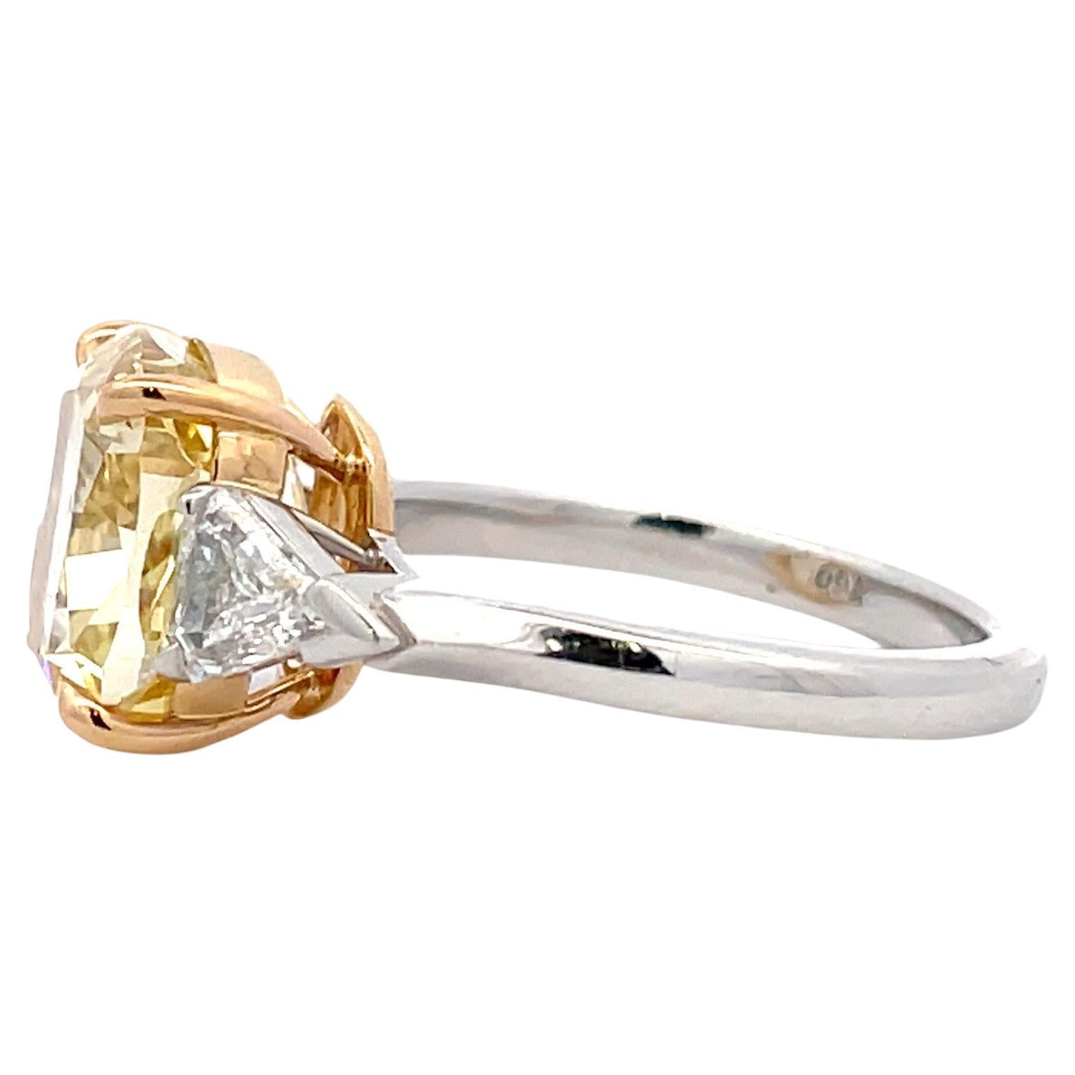 Three stone ring featuring one GIA Certified Fancy Brownish Yellow Cushion, 5.67 Carats, VVS1 Clarity flanked with two Kite diamonds weighing 0.67 Carats, in Platinum & 18 Karat Yellow Gold.

Diamonds Quality
Color E 
Clarity VS

