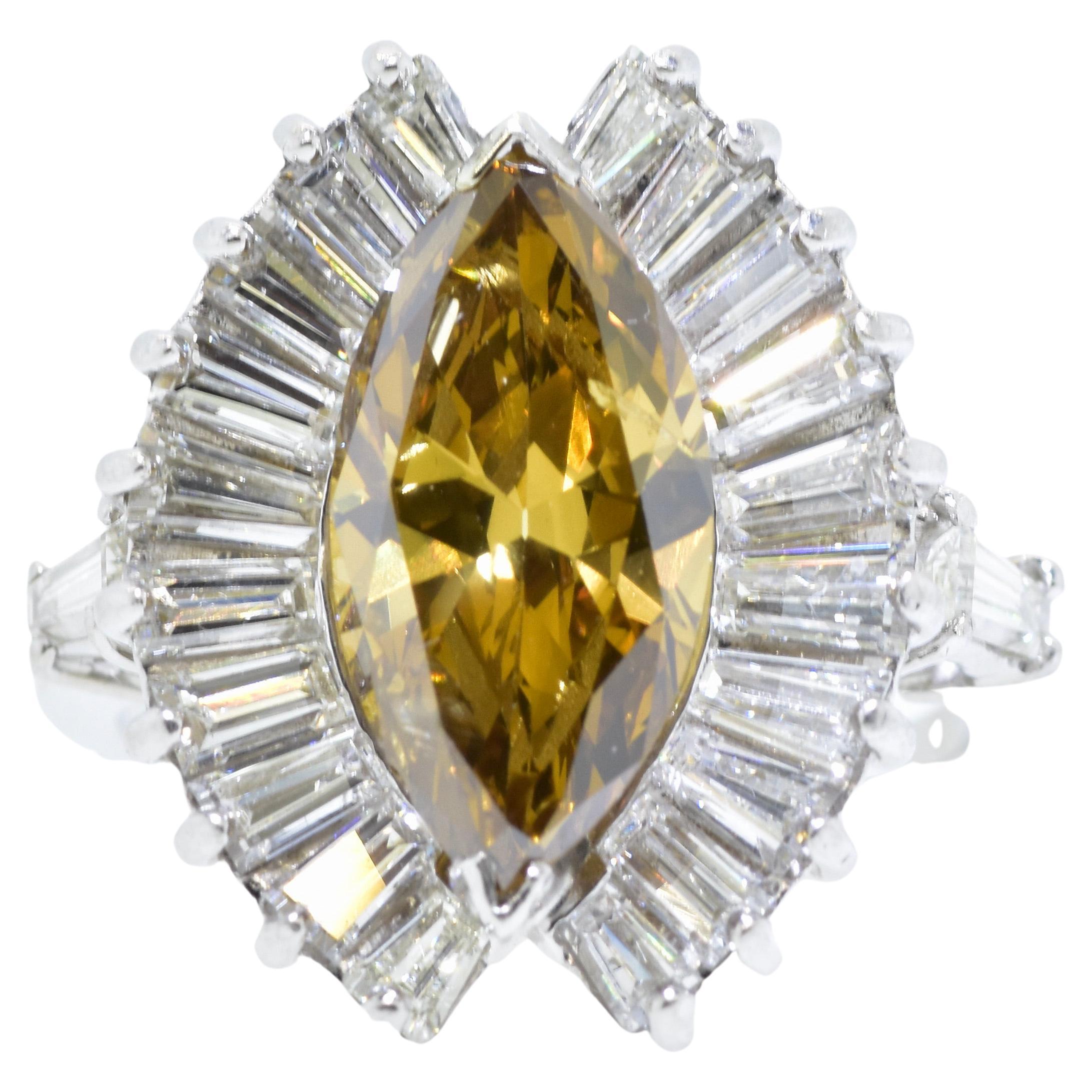 GIA 2.7 ct .natural yellowish brown marquis diamond with 1.5 cts of colorless tapered baguettes.  
The center marquis cut diamond has been examined by the Gemological Institute of America graded as a natural yellowish brown diamond weighing 2.7 cts.