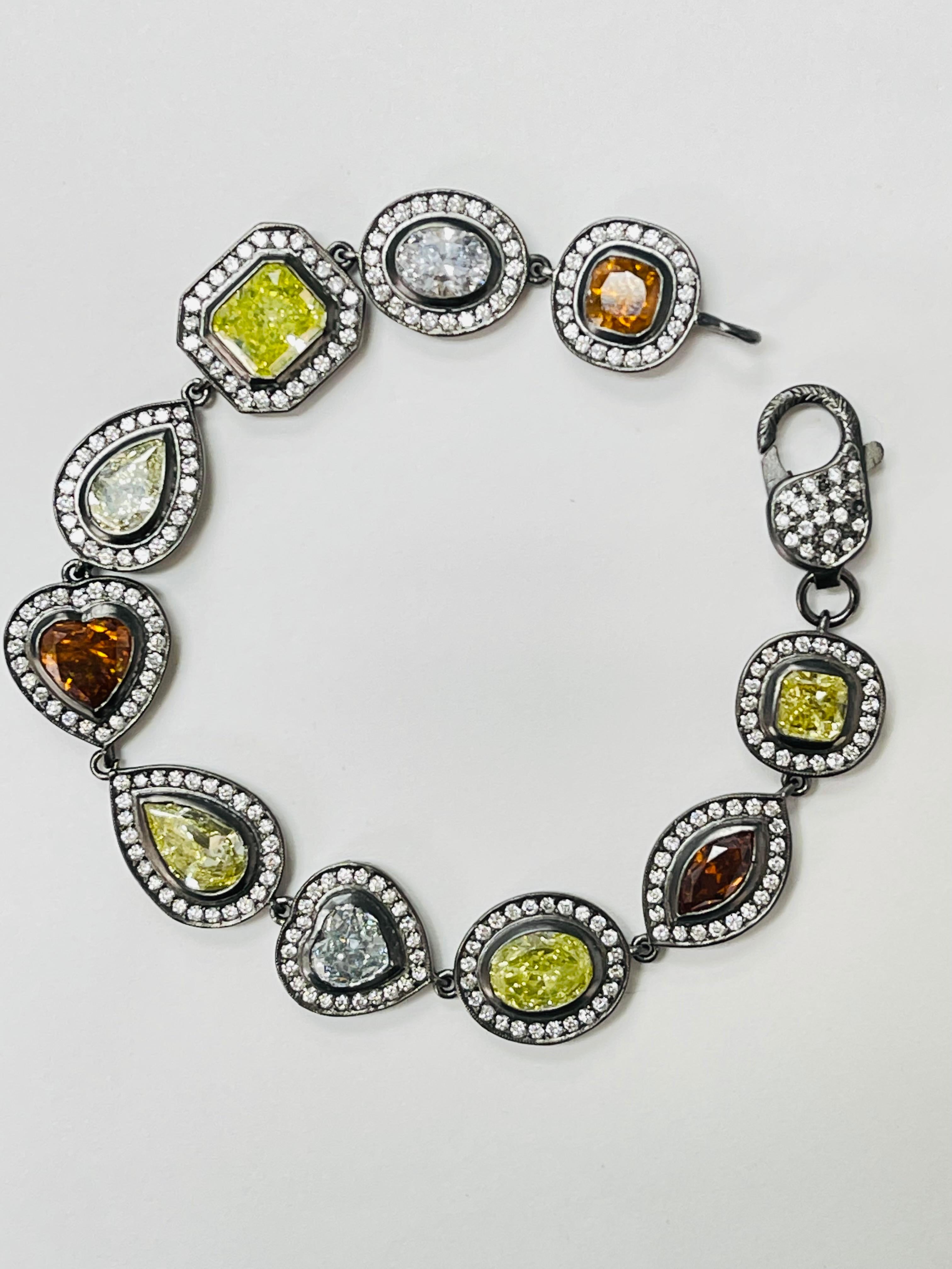 Ce bracelet en diamants de couleur et de forme fantaisie certifié par le GIA est absolument magnifique. Ce fabuleux bracelet de diamants de forme et de couleur fantaisie est magnifiquement réalisé à la main en or blanc 18 carats. 
Les détails sont