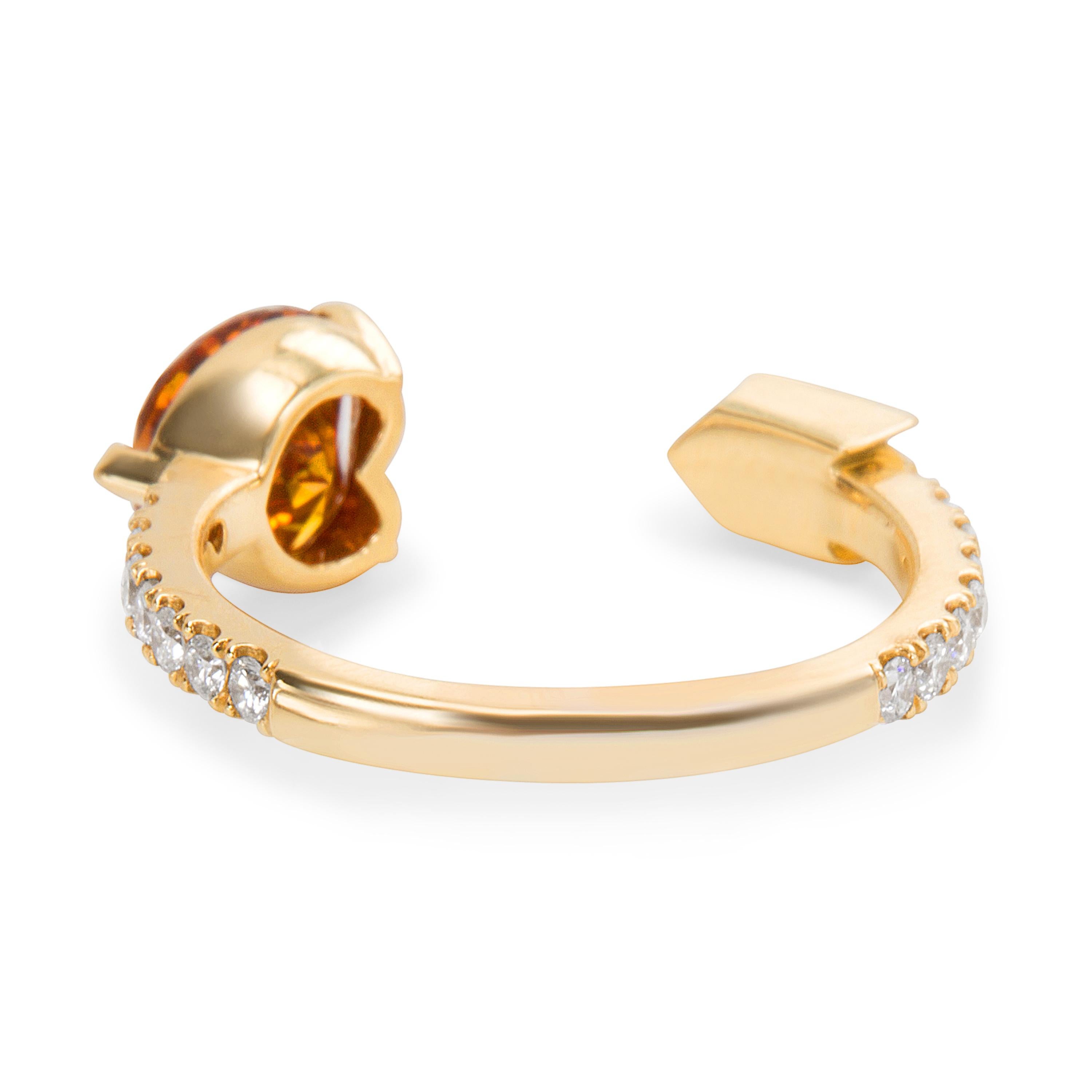 The simple 18K yellow gold setting, encrusted on most of its outer rim with small stones is simple and elegant. Its focal point though is the fancy yellow and orange diamond, fashioned into the shape of the diamond, adding a unique and statement