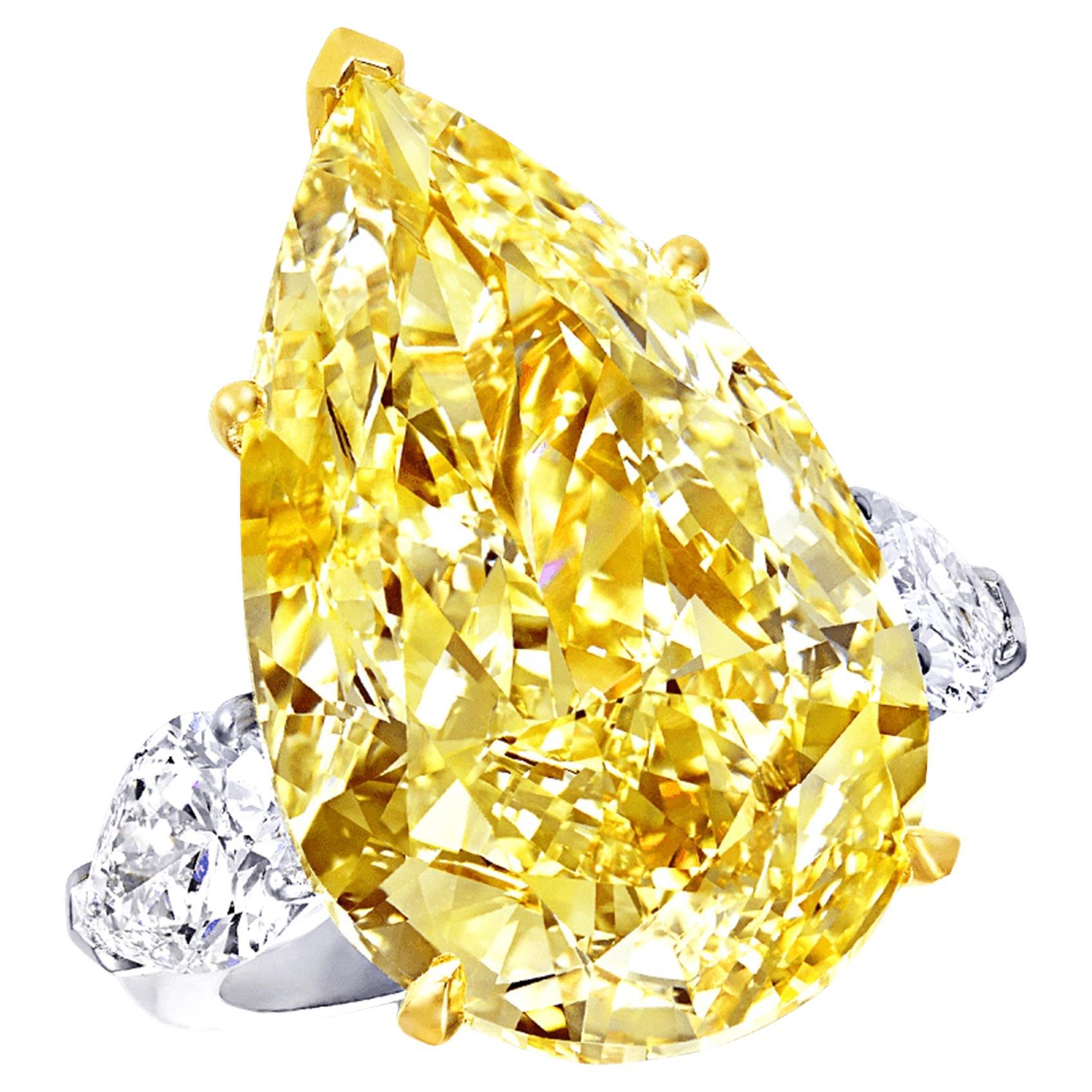 Introducing a breathtaking masterpiece of fine jewelry, this GIA Certified Fancy Intense Yellow 11.02 Carat Pear Shape Three Stone Diamond Ring is a symbol of exquisite luxury and unparalleled beauty. The centerpiece of this stunning ring is an