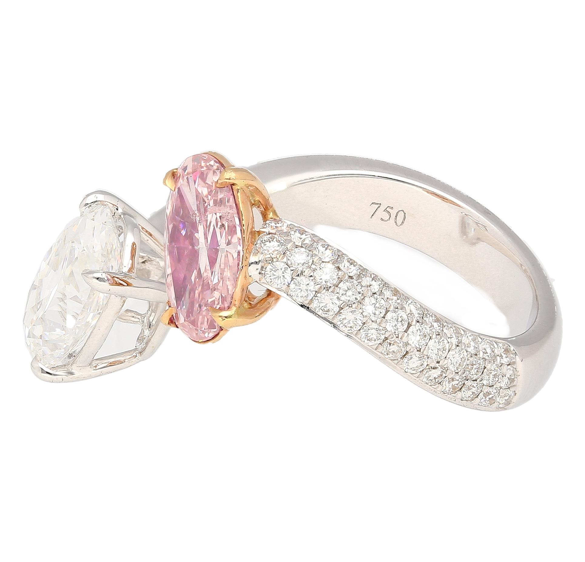 Crafted with unparalleled craftsmanship, this enchanting masterpiece unites two souls in perfect harmony. Set with a rare and captivating 1.01 carat Fancy Orangy Pink diamond, delicately mirrored by a 2.02 carat D color white diamond. This 