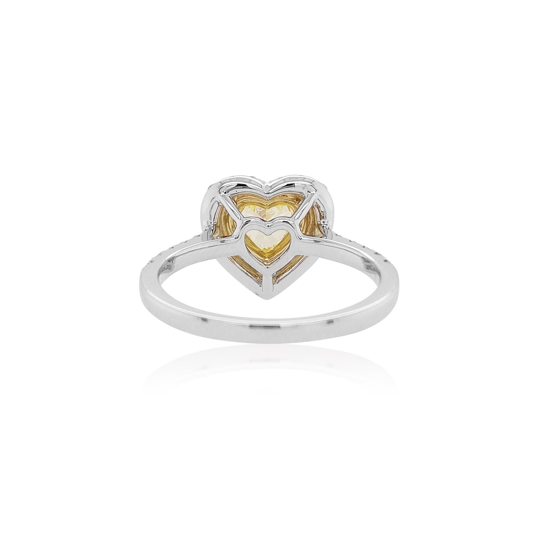 This lovely ring features lustrous Fancy Yellow Diamond above a playful diamond heart motif. Contemporary and elegant, this ring will add a touch of precious and tenderness whenever they are worn. The perfect gift for a loved one, this ring will