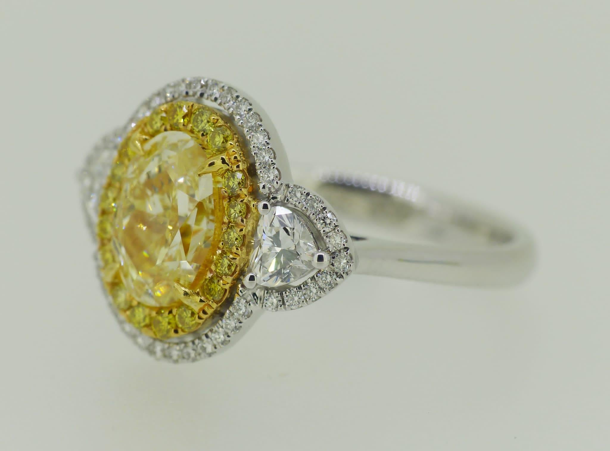 Stunning design for this incredible GIA diamond fancy light  yellow ct 2, VS2 and side diamonds heart cut ct 0,37 G/VS-SI and around diamonds round brilliant cut..