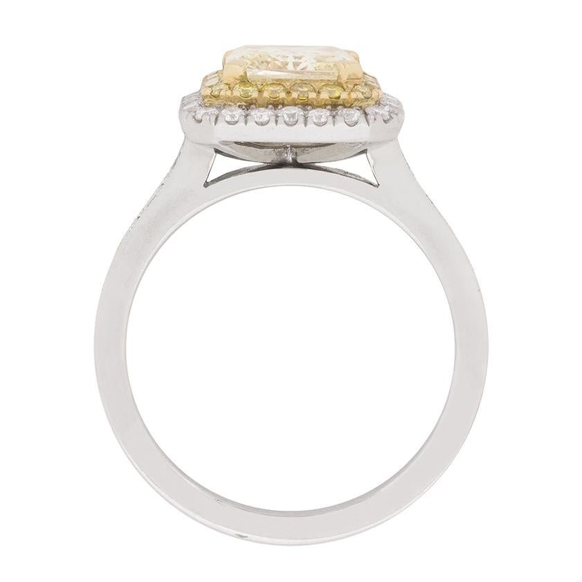 A gorgeous double halo of round brilliant cut diamonds frames a remarkable GIA certified, 1.72 carat, natural fancy yellow colour, princess cut diamond in the centre of this unique two-tone diamond engagement ring. The ring's design details