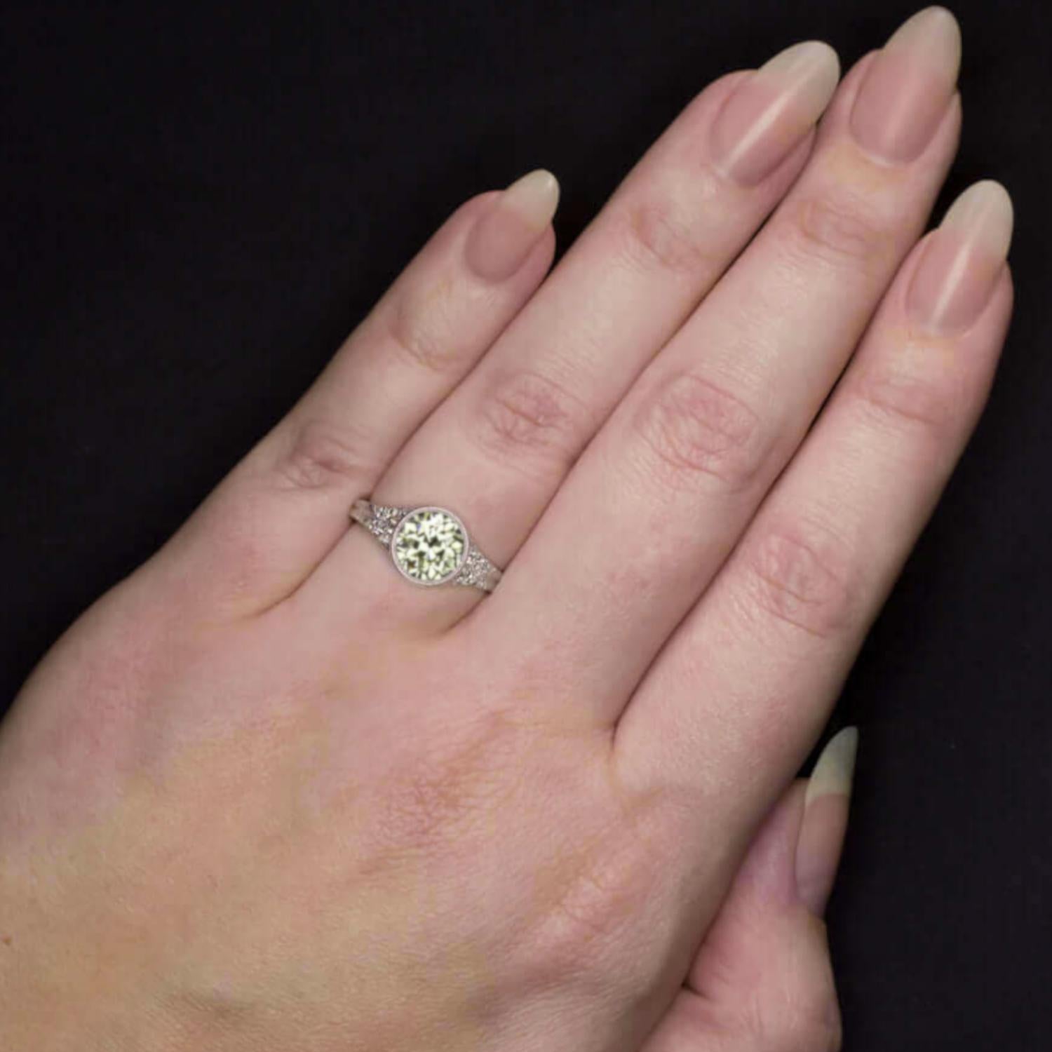 This enchanting Art Deco–inspired ring by Cecile Blake showcases a vibrant 0.88 carat Old European Cut diamond, GIA certified Fancy Yellow with exceptional VS1 clarity. The antique center stone radiates warm golden tones, beautifully set in a