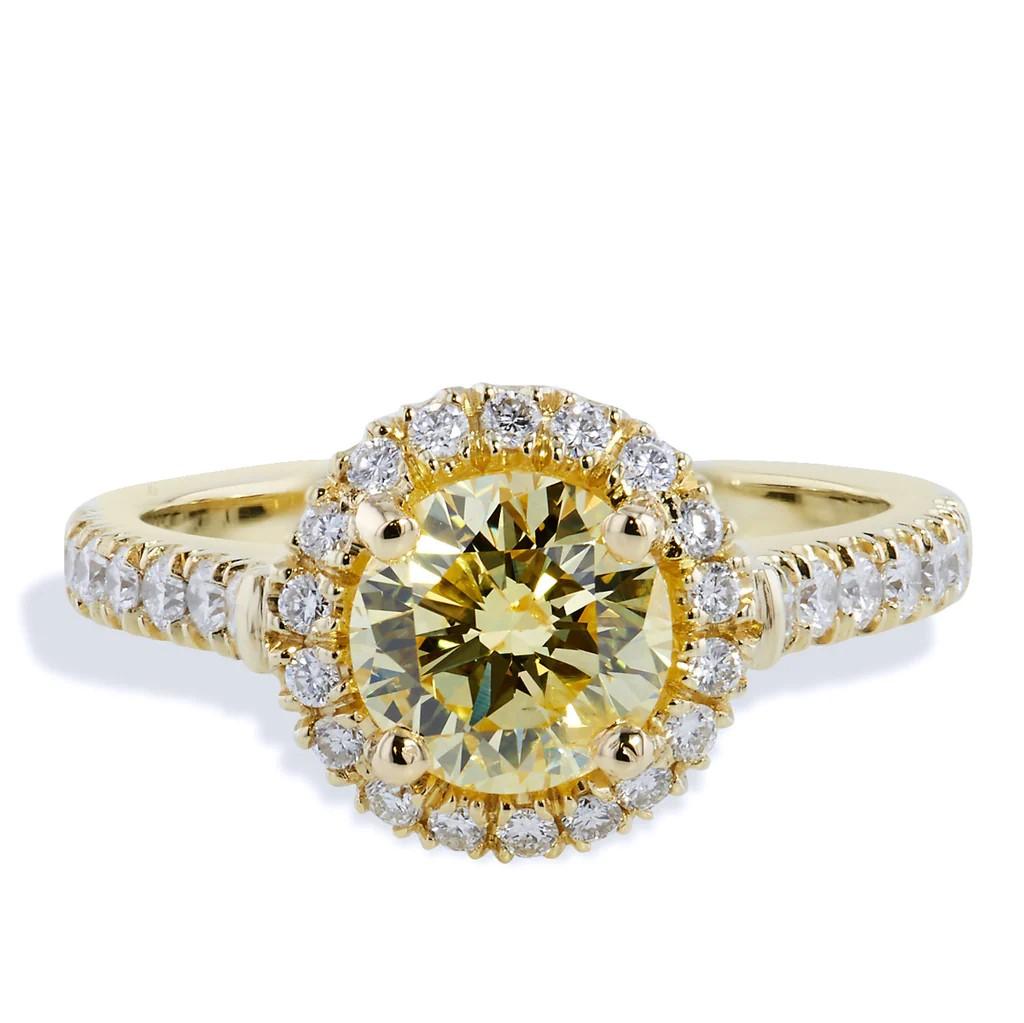 This ring is handmade in 18 karat yellow gold, which showcases a 1.33 carat fancy intense round brilliant cut yellow diamond. The center diamond is embraced by 0.44 carat (32 pcs) of pave set diamonds (F/G, VS-I1) that hug the middle and trail down