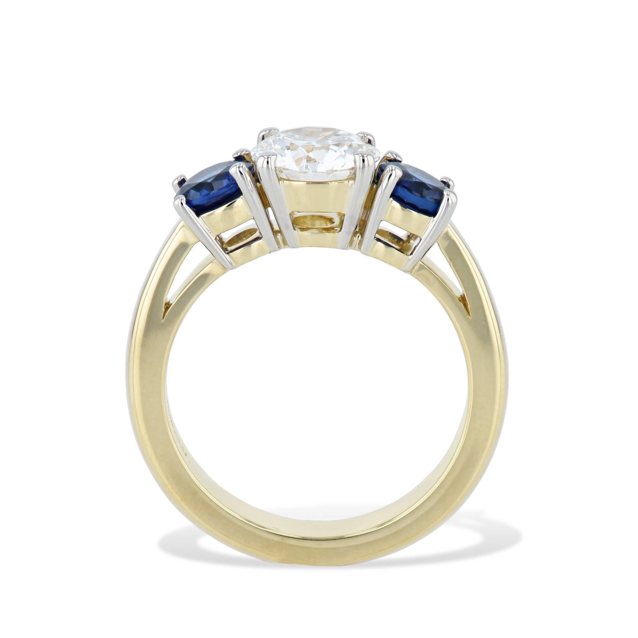
This elegantly crafted in luxurious 18kt gold, this 3-stone ring speaks to the sophistication of its wearer. At its center lies a 1.53CT round brilliant diamond, I in color and VS2 in clarity. This is framed delicately by two exquisite blue