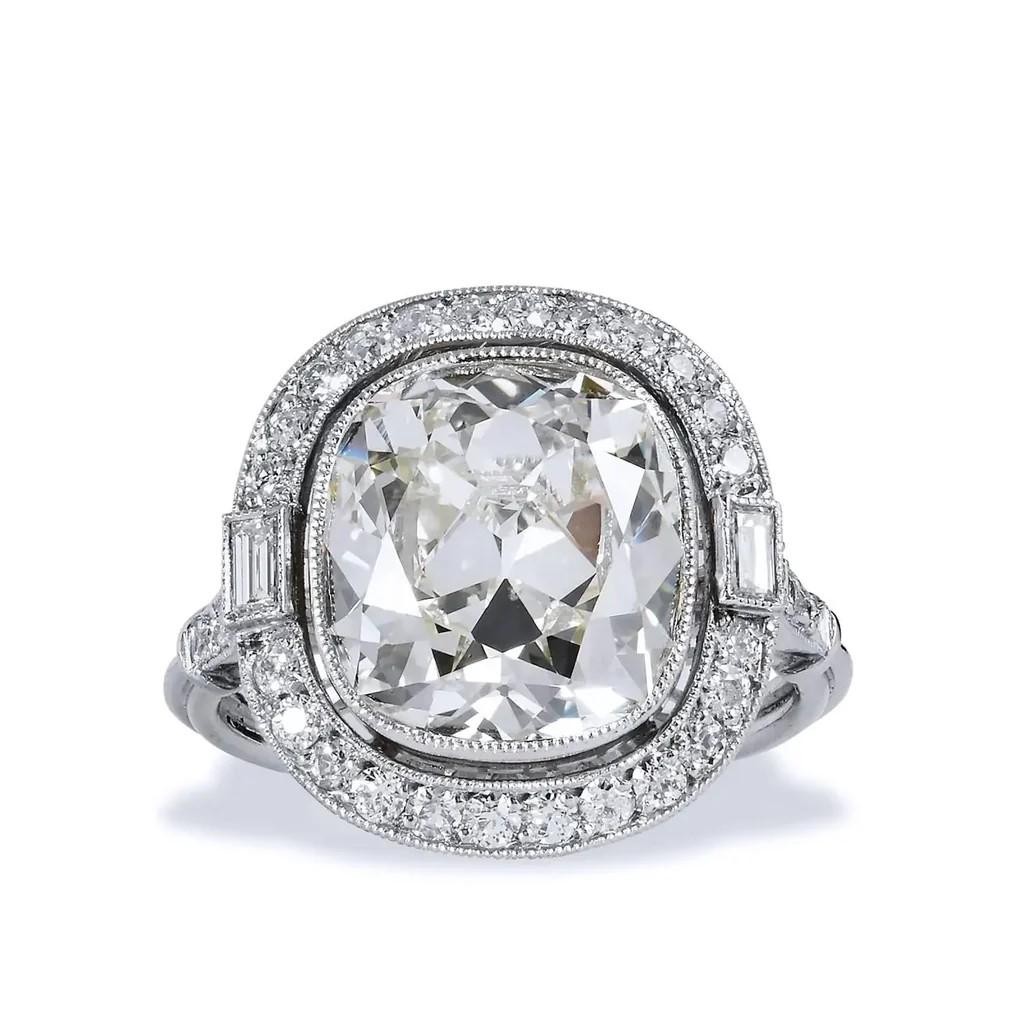 This gorgeous 6.53 carat diamond ring of platinum scores the highest marks. 

Designed and manufactured by H&H in Platinum, with a striking bezel set, 6.53 carat cushion brilliant diamond, surrounded by twenty six modern old European cut and