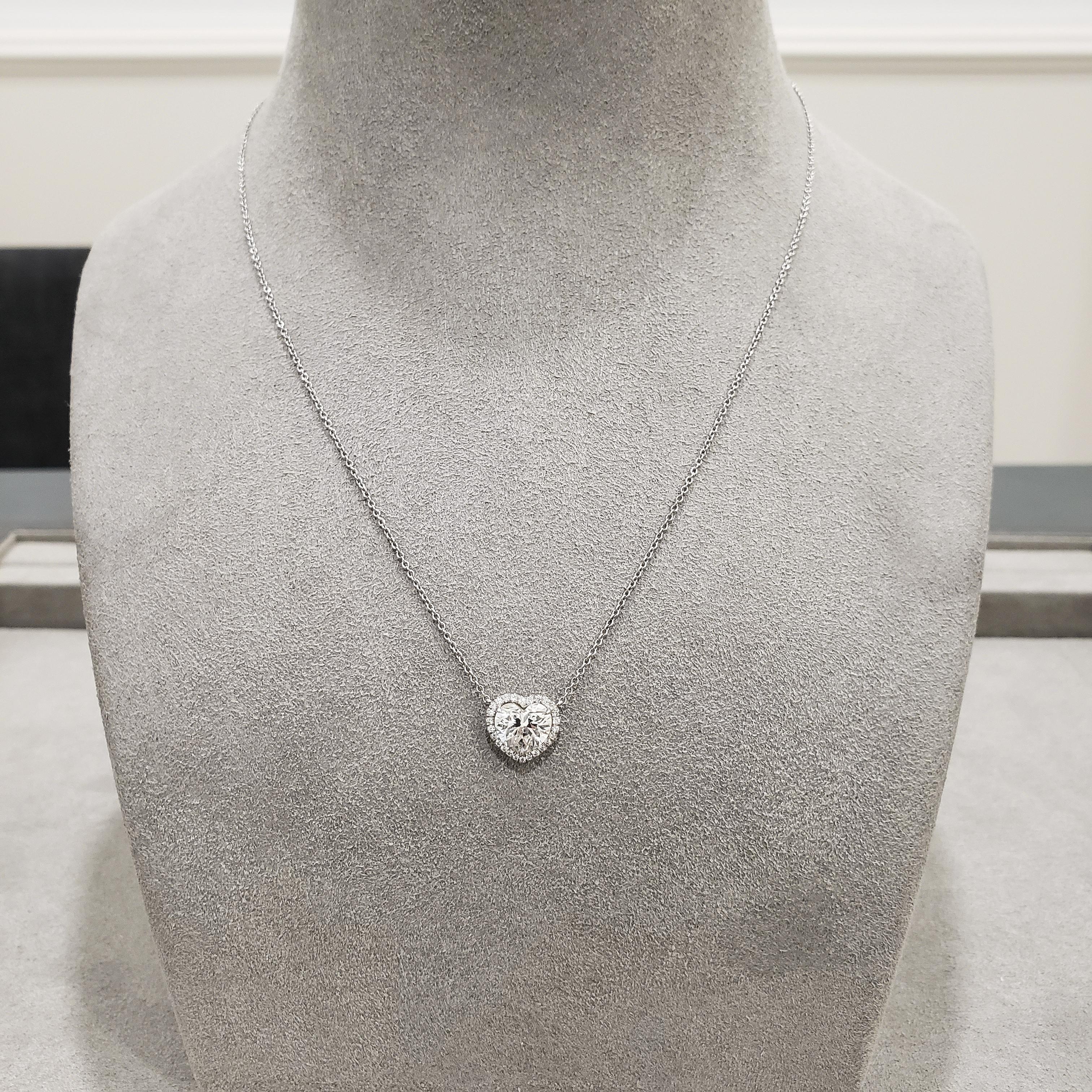 Showcasing a 1.81 carat heart shape diamond, certified by GIA as K color, SI2 clarity, surrounded by a halo of round brilliant diamonds weighing 0.20 carats total. Attached to a 16 inch chain. Made in platinum.

Style available in different price