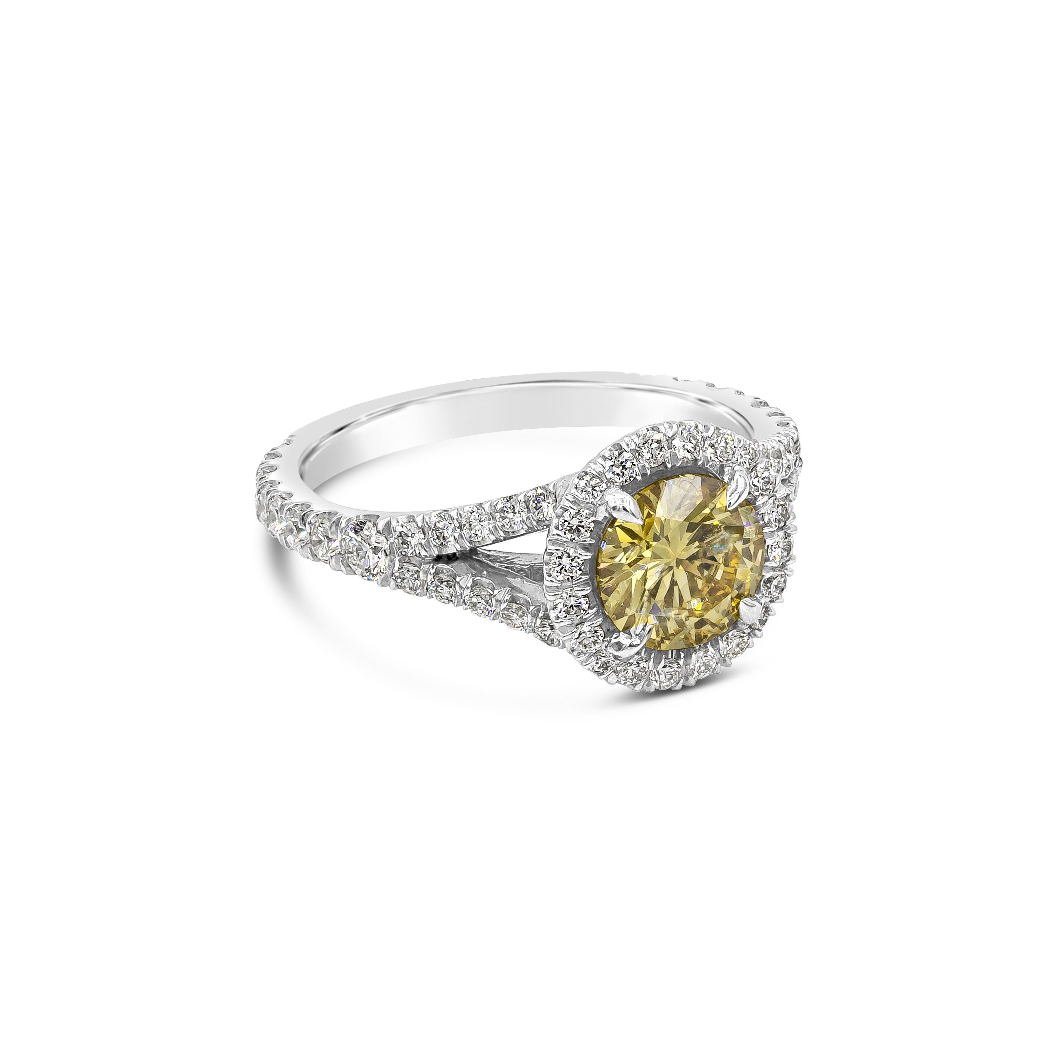 An appealing engagement ring showcasing a GIA Certified round cut diamond, Fancy Intense Yellow in Color and SI1 in Clarity. Surrounded and Accented by brilliant round diamonds in a chic split shank setting, Diamonds weighs 1.02 carats total. Made