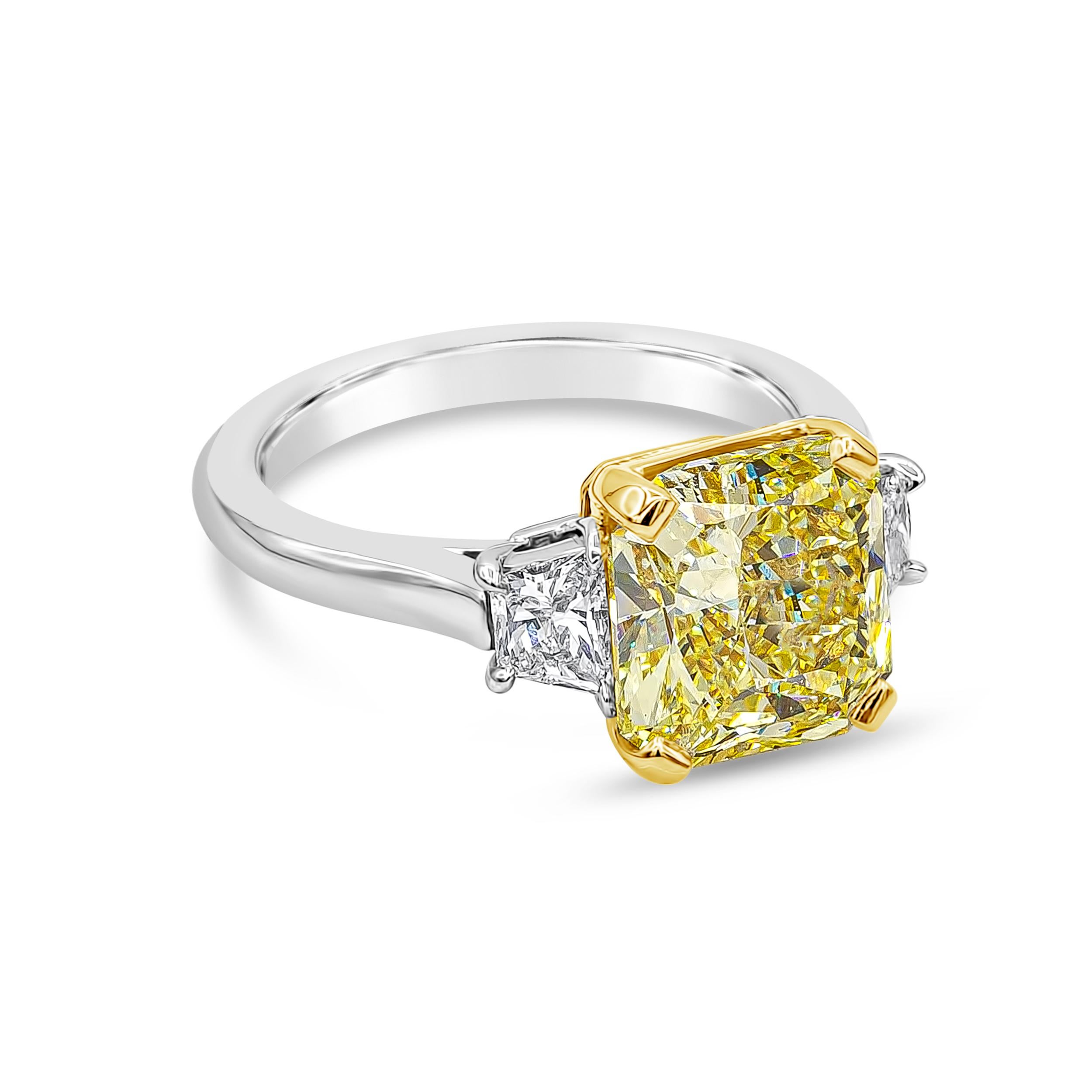 Well crafted high end engagement ring showcasing a GIA certified color-rich fancy yellow color 3.64 carats radiant cut diamond, VS1 in clarity. Accented with trillion diamonds on each side weighing 0.56 carats total and is set and finely made in
