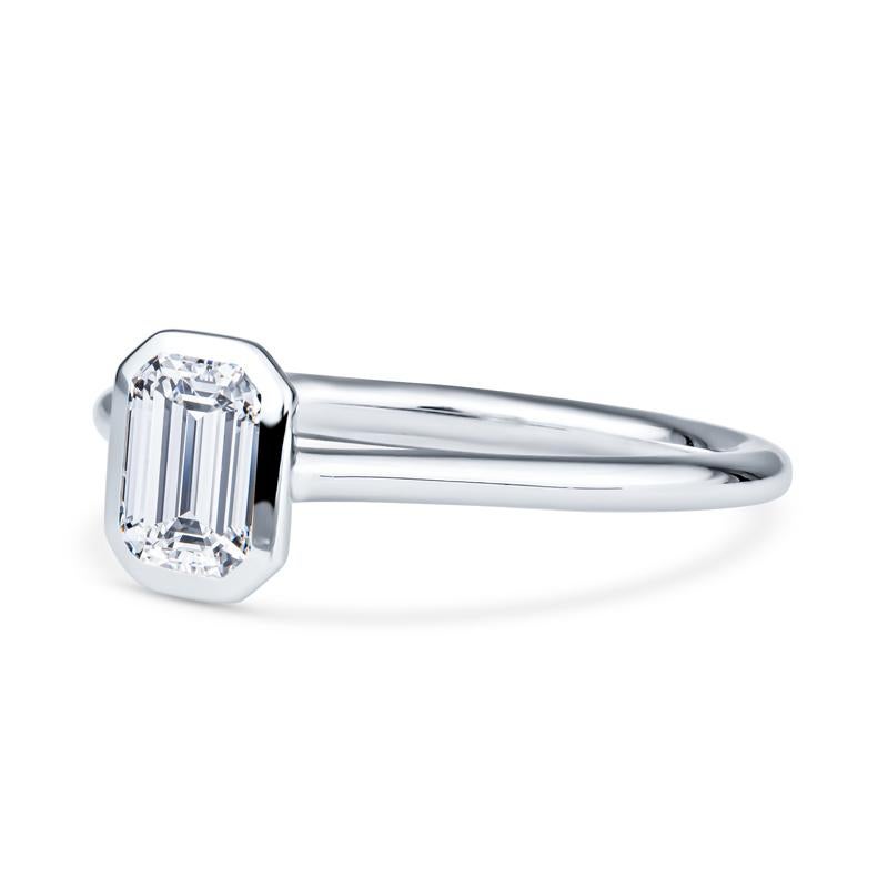 This modern engagement ring features a bezel set GIA certified internally flawless 1.01 carat emerald cut diamond, color E set in 18 karat white gold. This ring is very unique and will definitely turn heads. It is a size 7.5 but can be resized upon