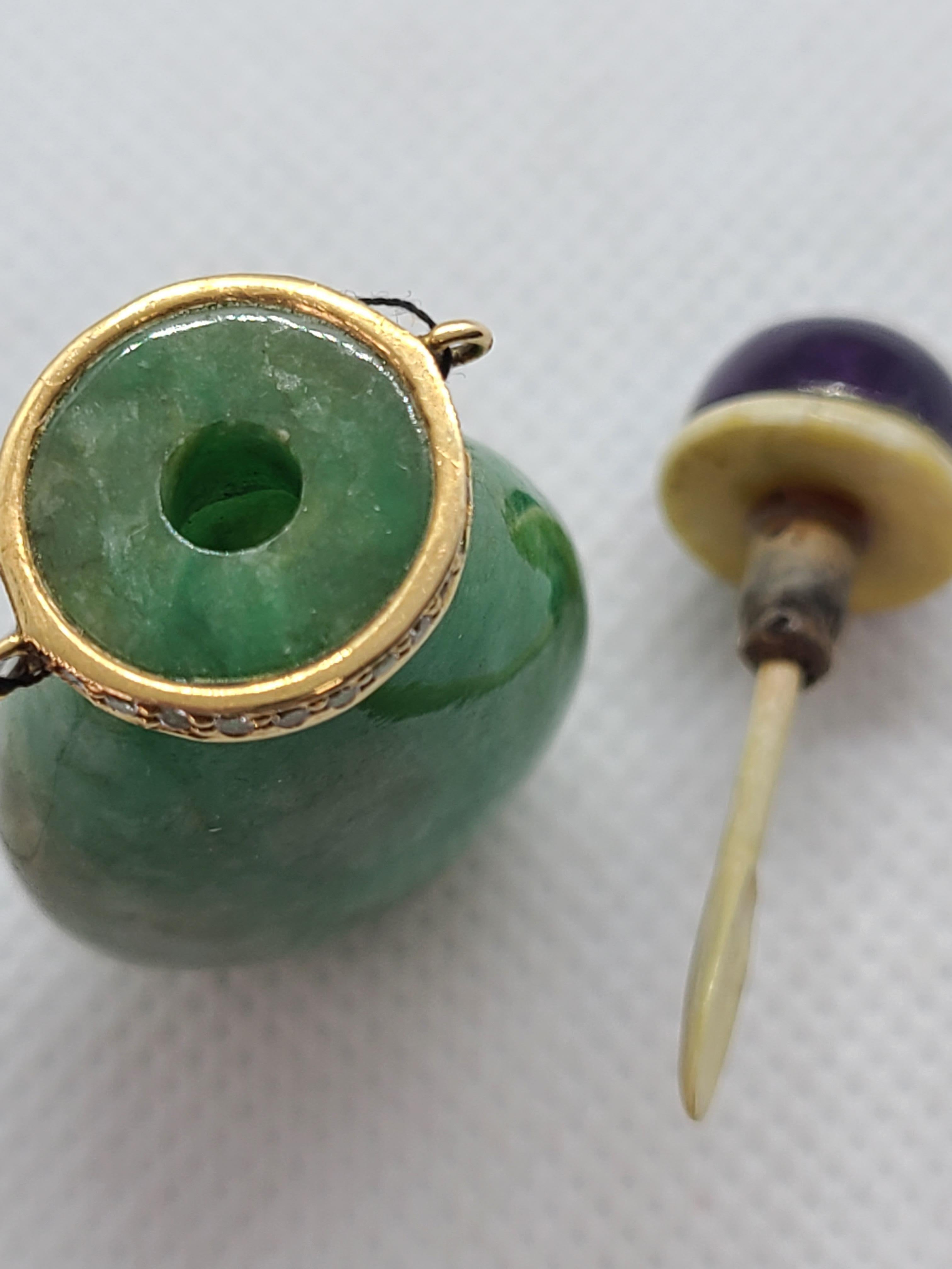 Il colore naturale traslucido verde e marrone della giadeite è scolpito come una boccetta da fiuto, sormontata da numerosi diamanti tondi brillanti quasi incolori. Il pezzo è completato da un tappo di ametista naturale, che crea un armonioso