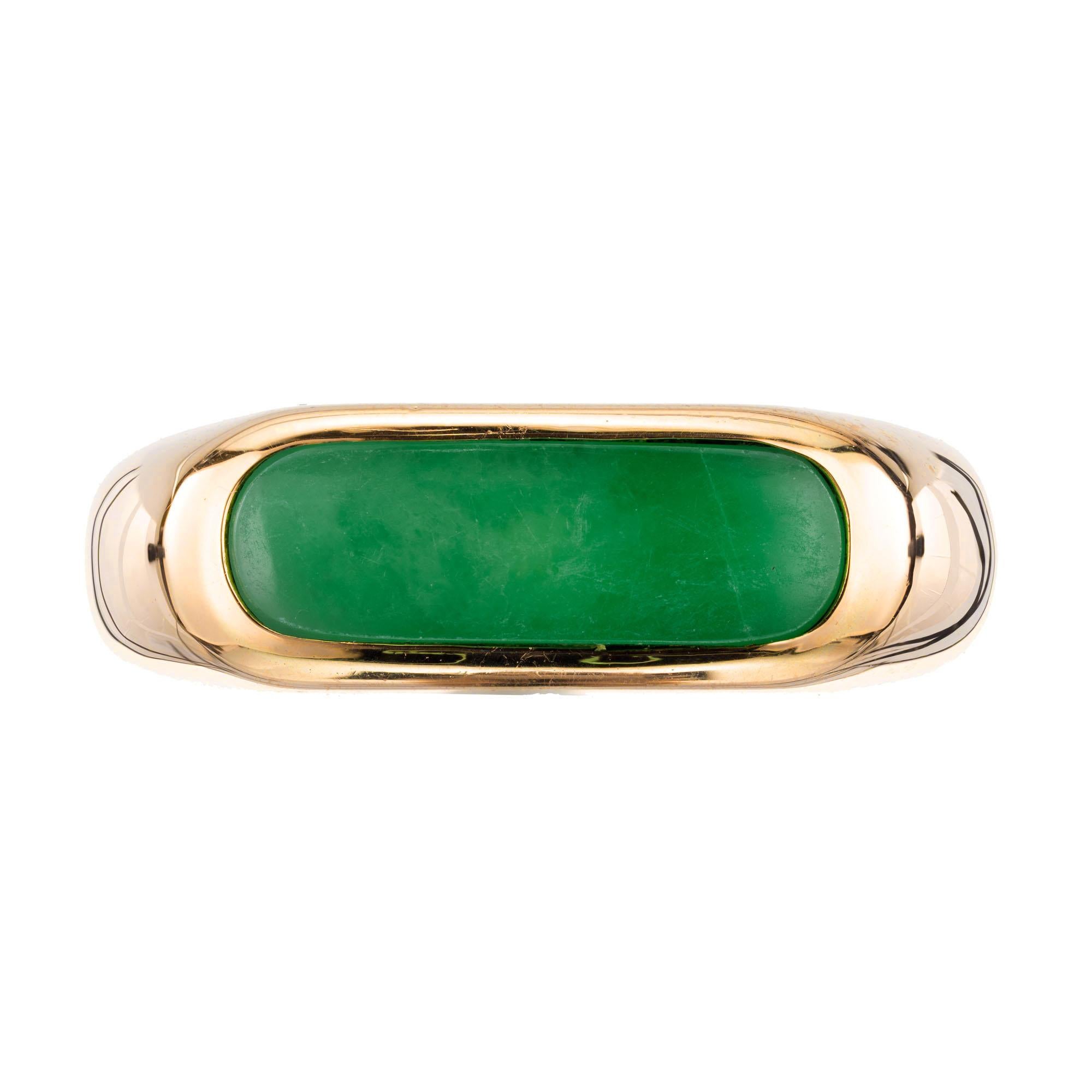 GIA certified natural color Jadeite Jade saddle ring, set in 14k yellow gold setting.  

1 oblong oval green cabochon jadeite jade GIA Certificate # 2205197695
Size 8.25 and sizable 
14k yellow gold 
Stamped: 14k
4.9 grams
Width at top: 6.8mm
Height