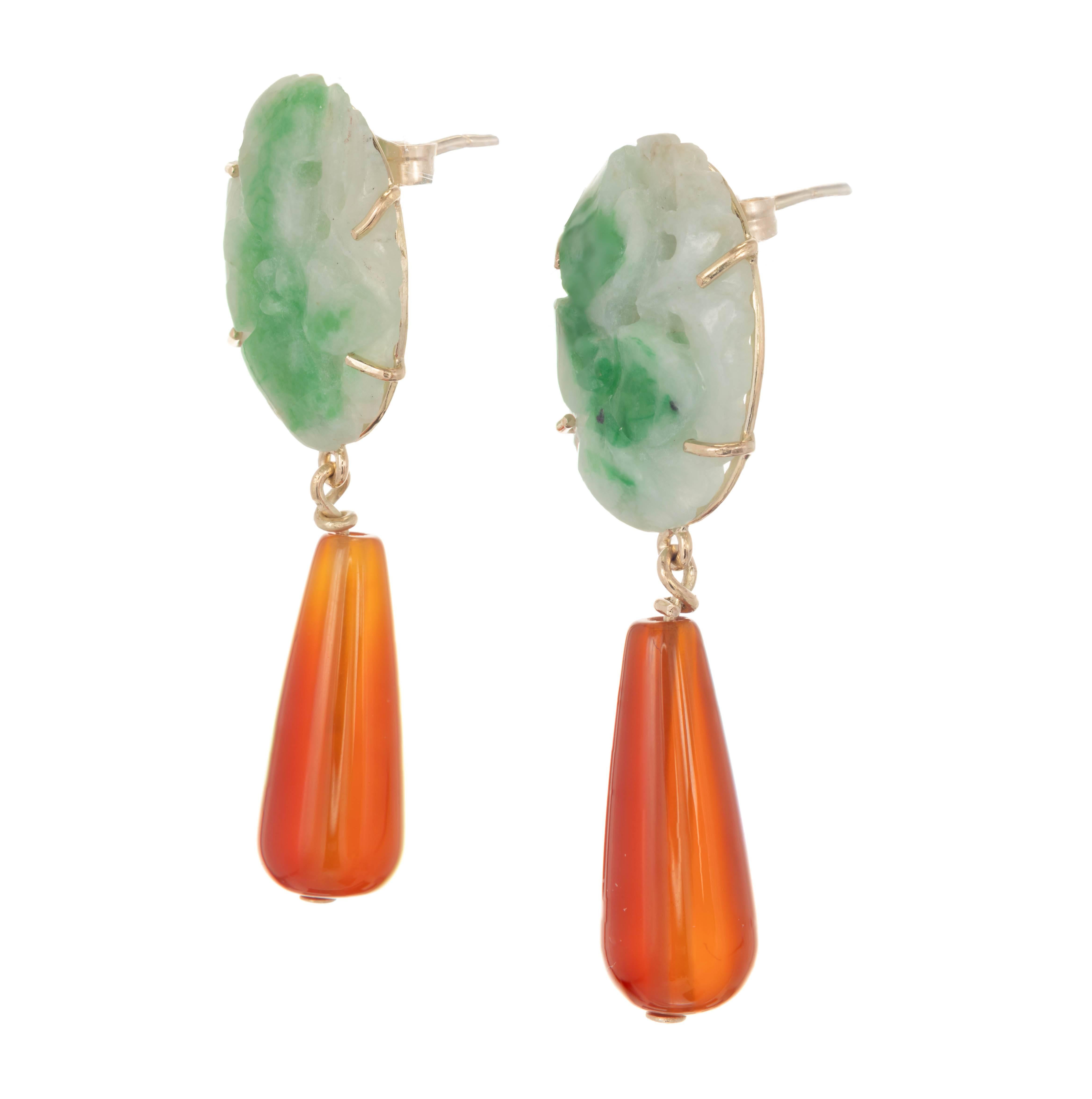 Pair of 14k yellow gold green jadeite and carnelian dangle earrings. Oval pierced carved jadeite jade stones of mottled green color are set above an orangish carnelian teardrop.

2 oval pierced carved mottled green jadeite jade 17.99-17.92 x