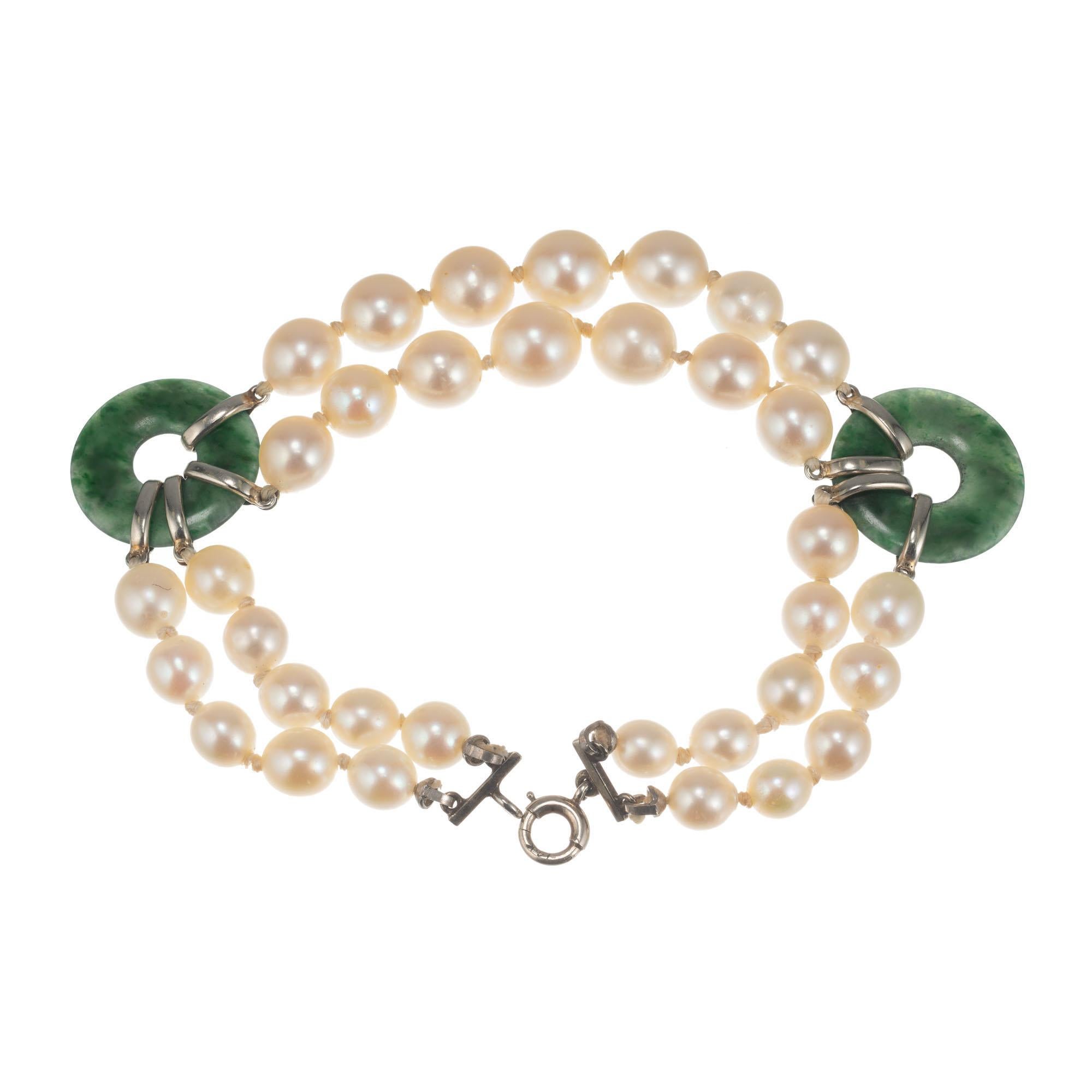 Mid-Century GIA certified natural color jadeite jade discs, lustre enhanced pearl bracelet. Graduated semi baroque graduated two strand cultured pearls with a 14k white gold clasp. 7 inches in length.

 14k white gold bracelet
2 green jadeite jade