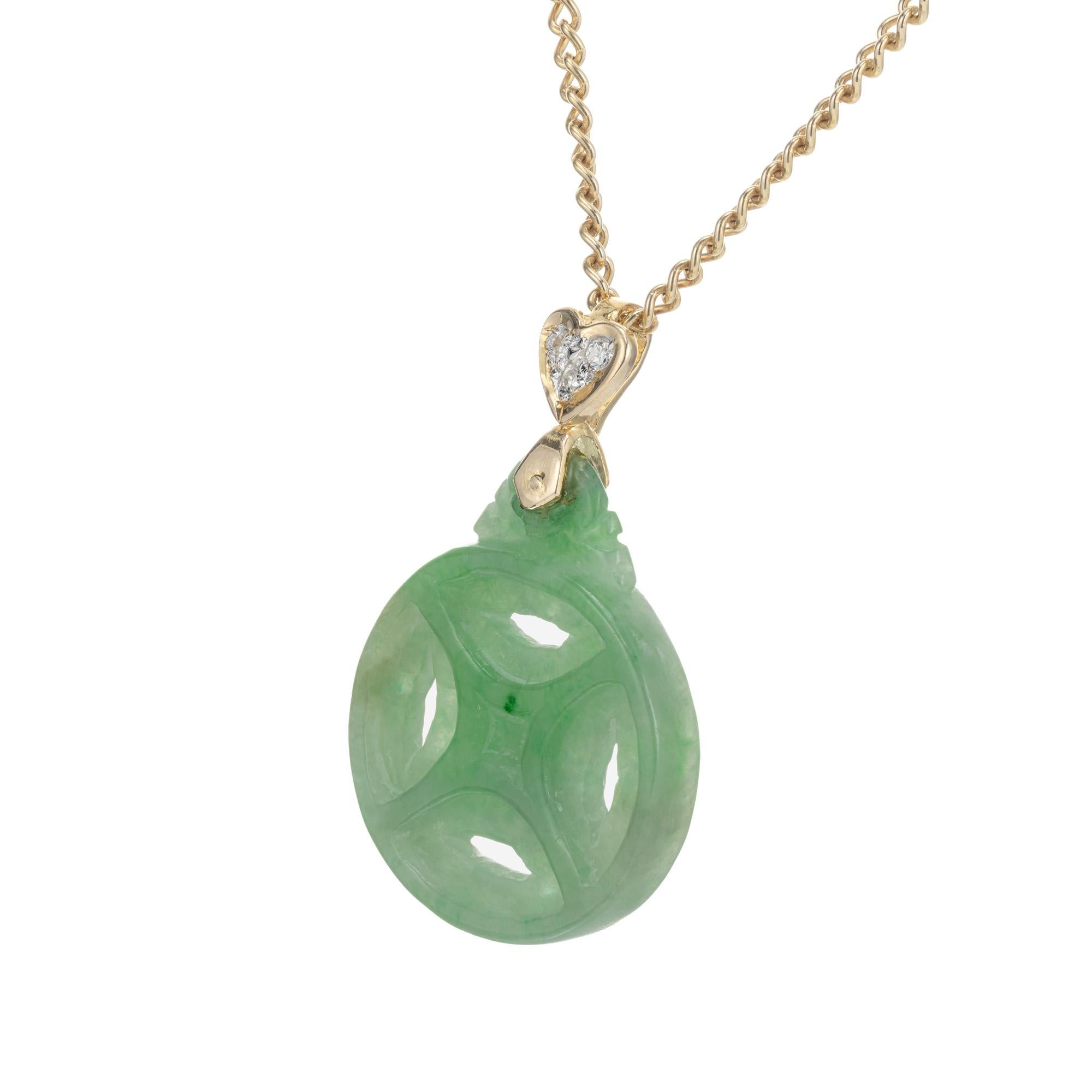 Jadeite Jade and diamond pendant. GIA certified Carved round natural color jade, no indications of impregnation, pendant with 3 round diamonds in a heart shaped 18k yellow gold frame. 16 inch 18k yellow gold chain. 

1 round carved jadeite jade