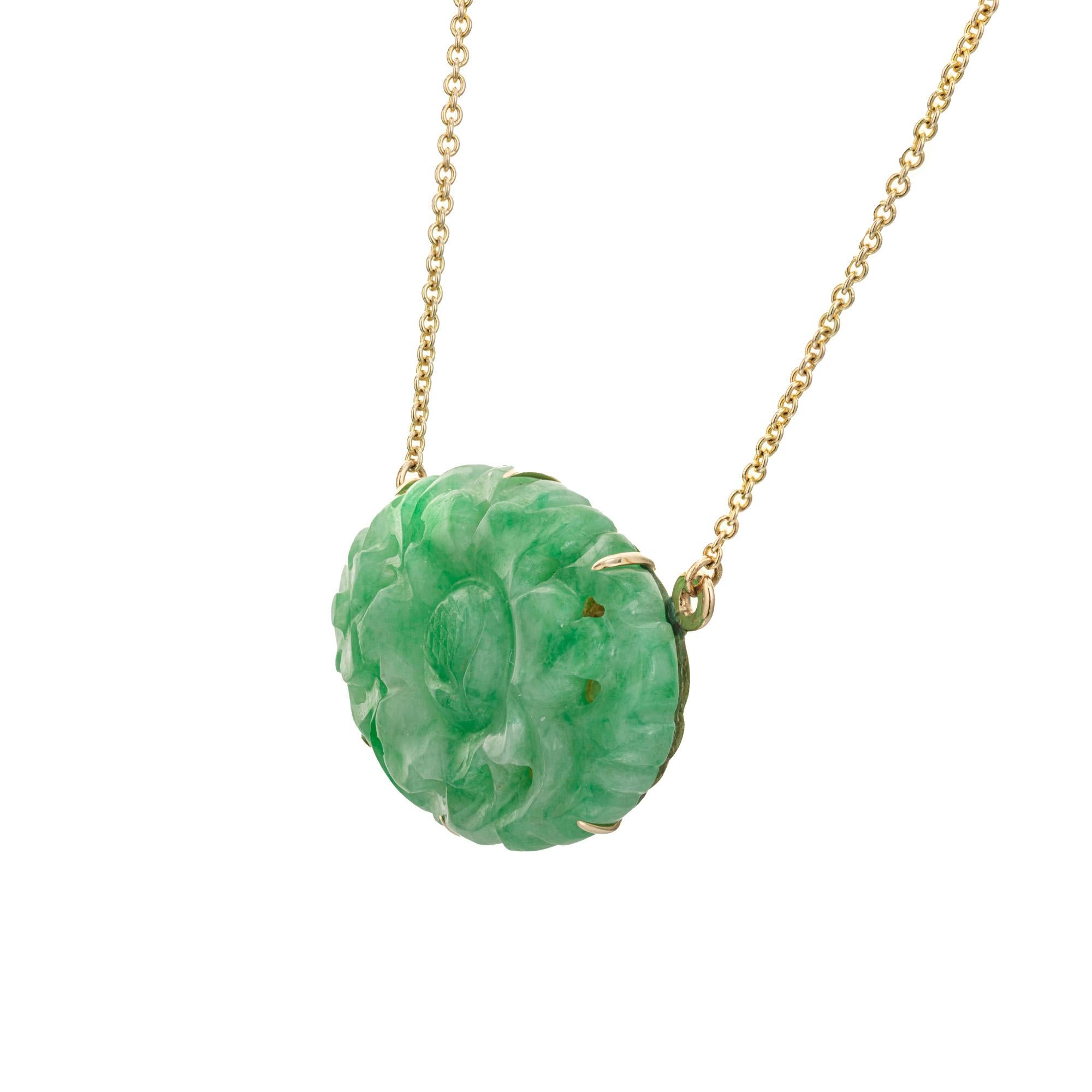 Natural untreated jadeite jade oval carved flower pendant. GIA certified A grade oval carved and pierced mottled jade with a 19 inch yellow gold chain. 

1 oval pierced carved mottled green jadeite jade, GIA Certificate# 6223168161
14k yellow gold