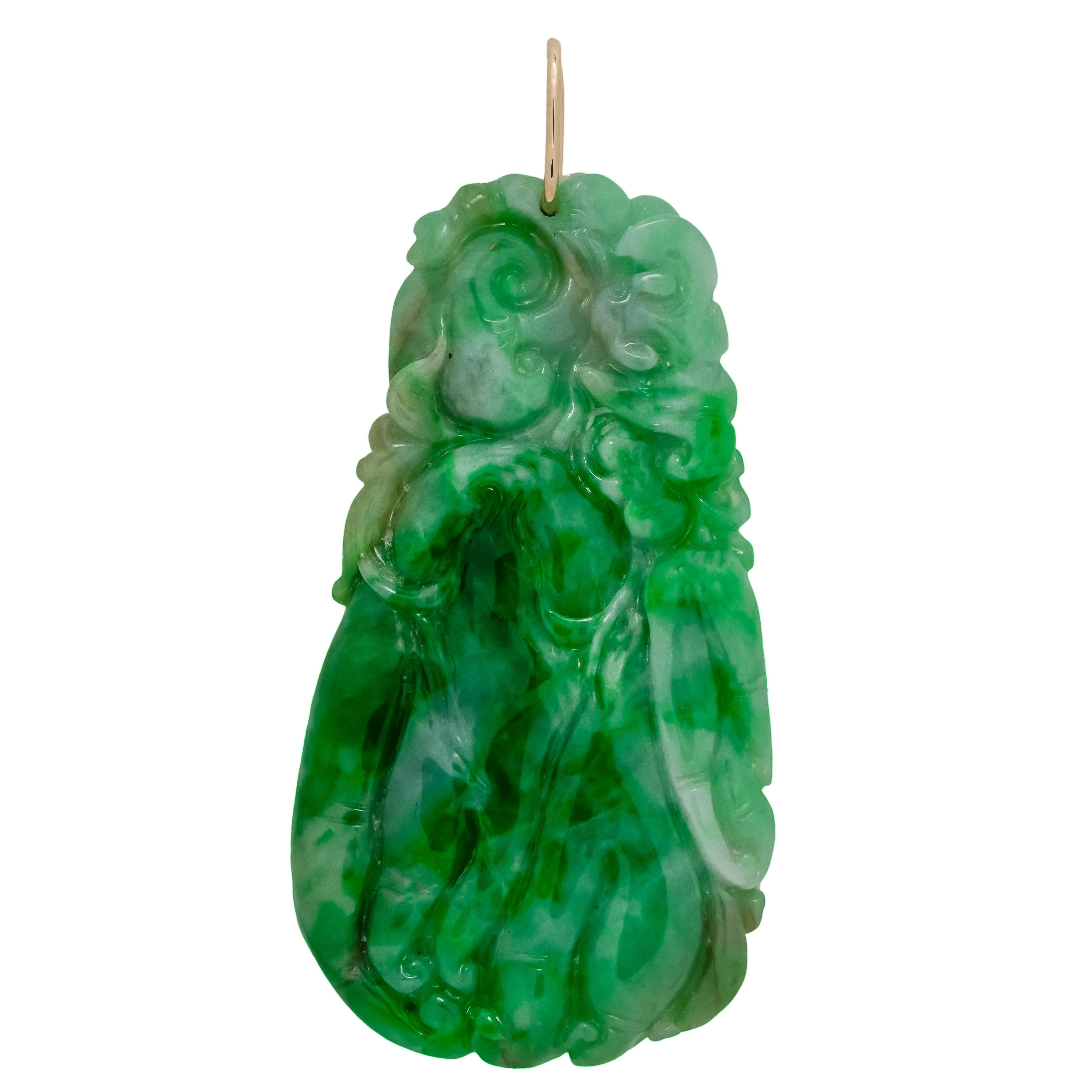Pendente scolpito in giadeite naturale del 1950 con un semplice anello in oro giallo 14k.  L'anello è stato testato a 14k variegato di colore verde extra fine. Intaglio a doppia faccia con un design fluido e profondamente intagliato. GIA lo ha