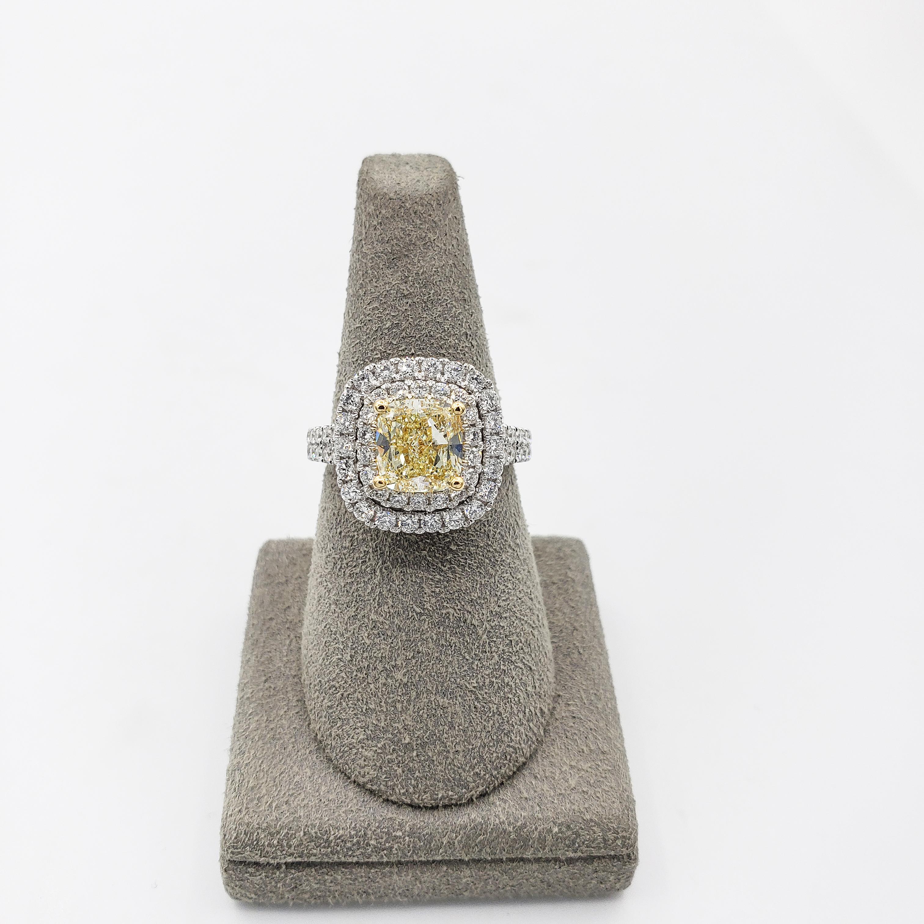 A brilliant engagement ring showcasing a 2.02 carats Fancy Yellow diamond that GIA certified as W-X color and SI1 in clarity. Elegantly set in a double halo surround encrusted with round diamonds, four prong made with 18K yellow gold. Shank is