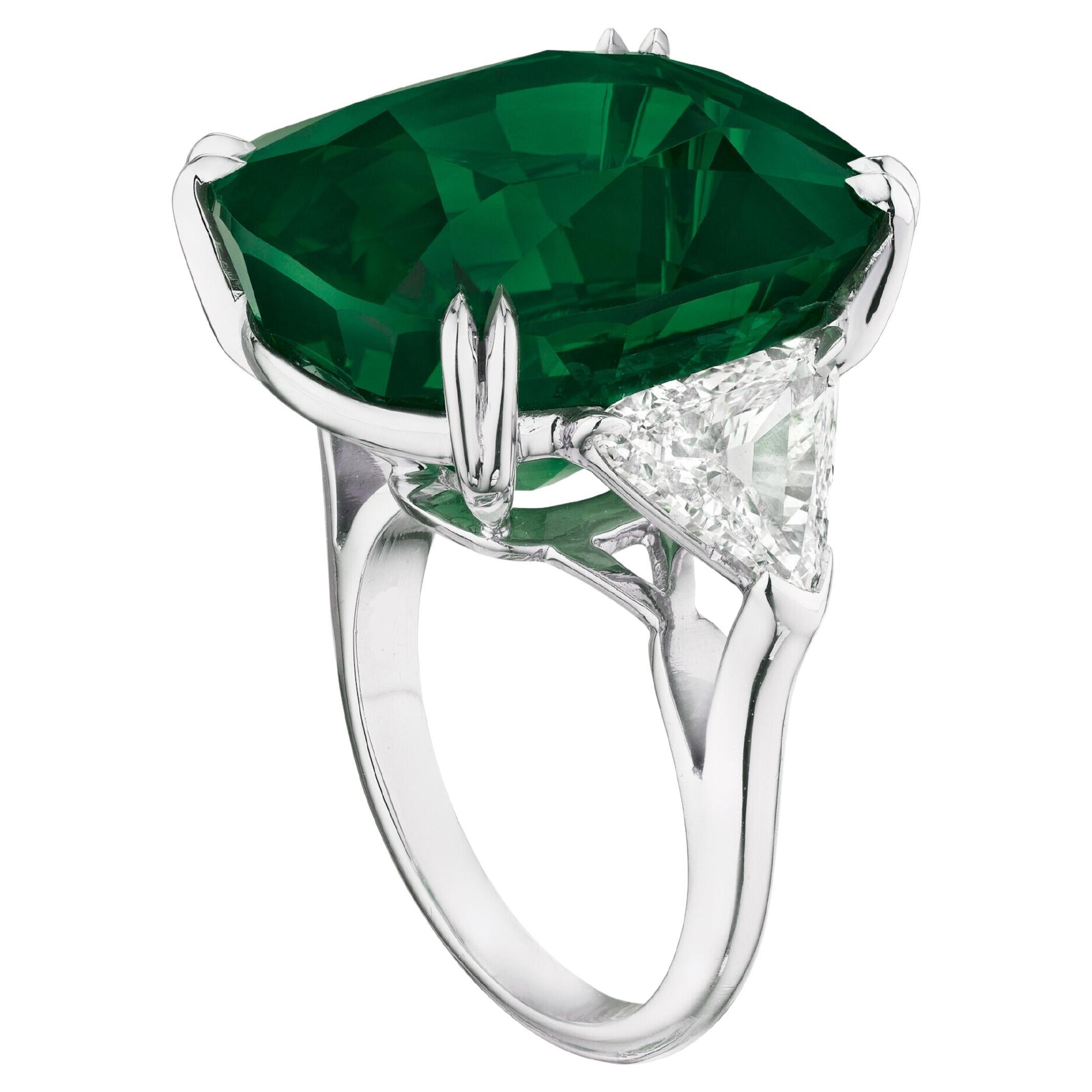This stunning ring features a certified natural emerald weighing 9 carats, complemented by elegant trapeze-cut diamonds on either side. The vibrant green of the emerald is beautifully highlighted by the sleek setting, creating a captivating and