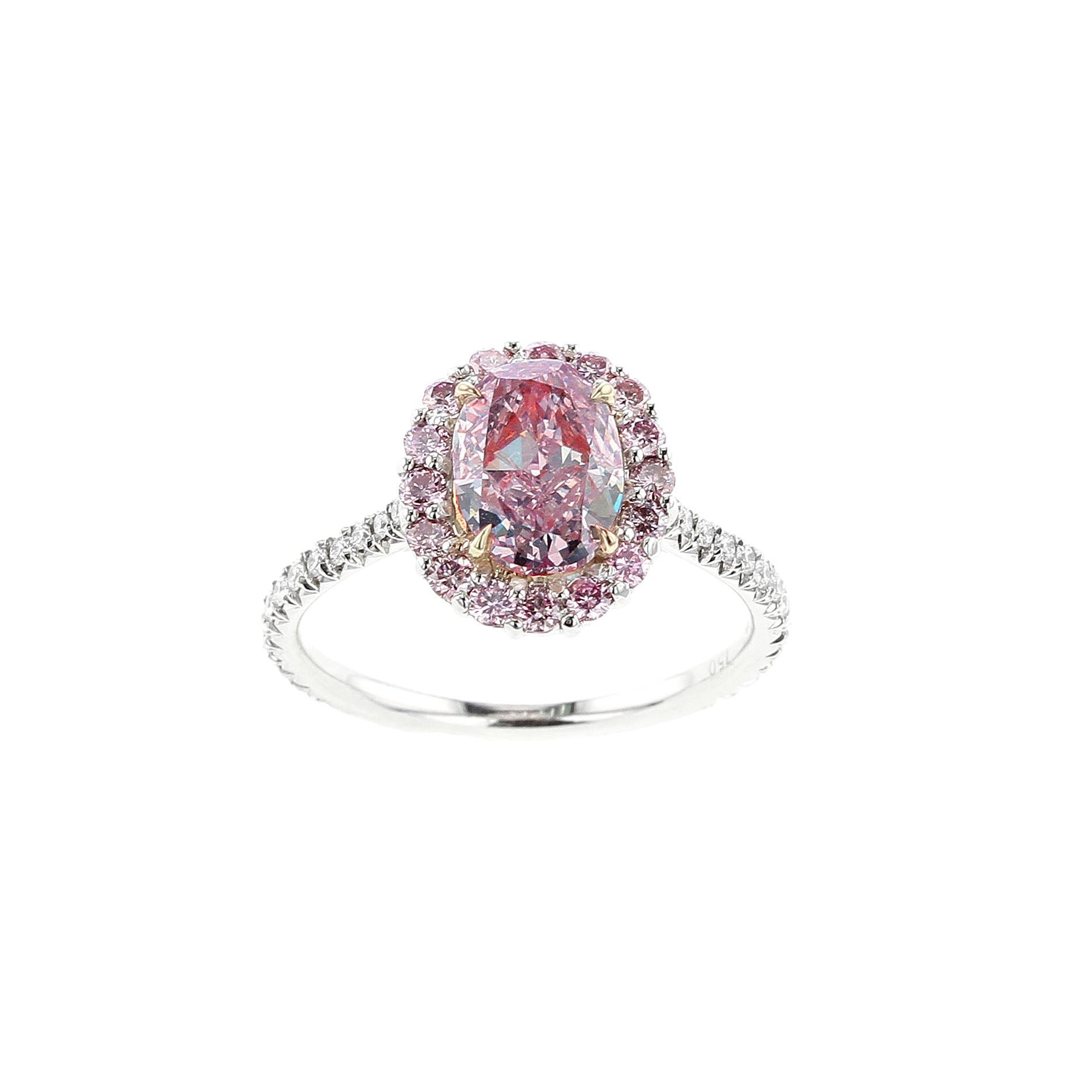 A beautiful and elegant ring centered with a natural oval-shape, Fancy Purplish Pink diamond, accented with a cluster of round brilliant-cut pink diamonds, with white round brilliant-cut diamonds along the shank. The center stone accompanies a