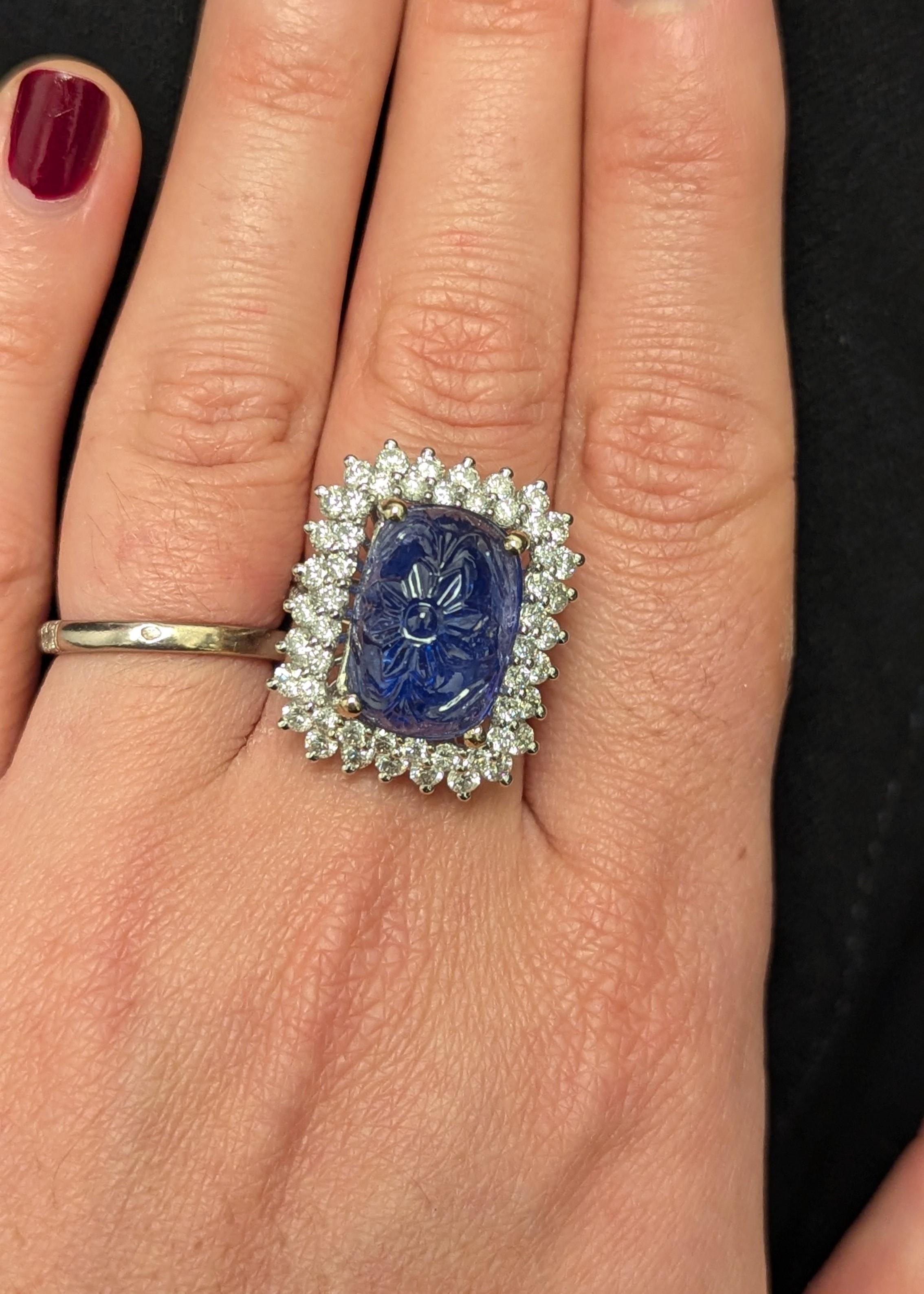 This intricately carved cushion-cut sapphire futures a beautiful a flower motif and weighs 12.89 carats. 

It is accented with approximately 2.66 carats of near colorless round-cut diamonds set on 14k white gold.