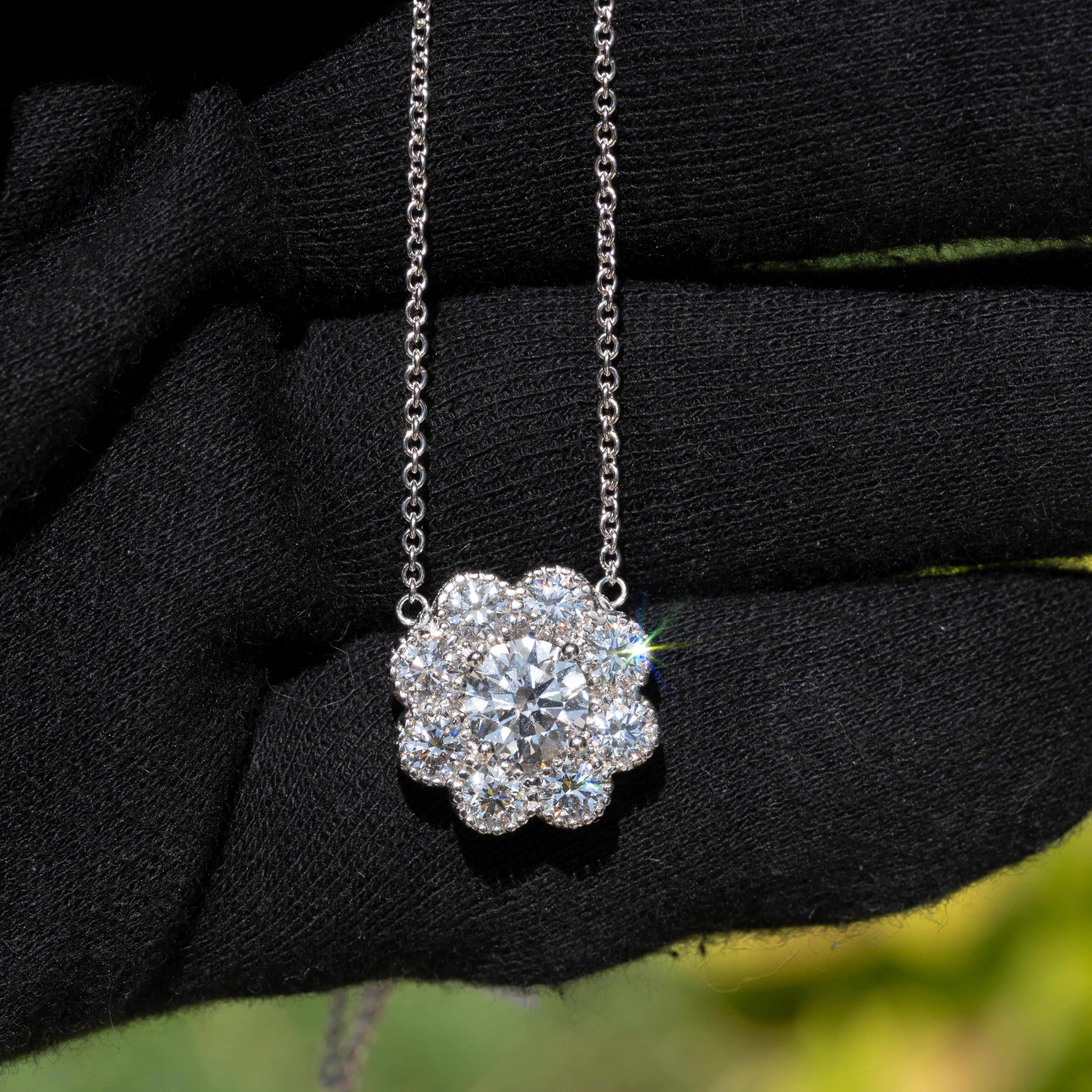 This luxurious necklace features a high-quality, GIA certified 1.90-carat round brilliant diamond as its centerpiece, surrounded by additional diamonds to create a total carat weight of 3.98 carats. The primary diamond boasts top grades in color