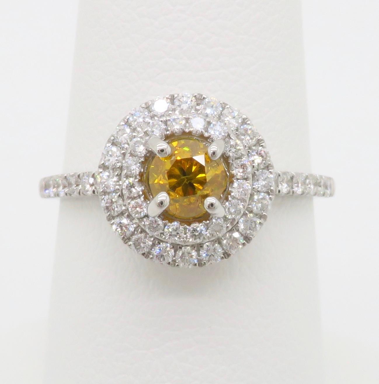 Superbe diamant certifié GIA de couleur jaune-orange vif serti dans une magnifique bague à double halo de diamants. 

Poids en carats du diamant central : .51CT
Taille du diamant central : Taille Brilliante ronde 
Couleur du diamant central :