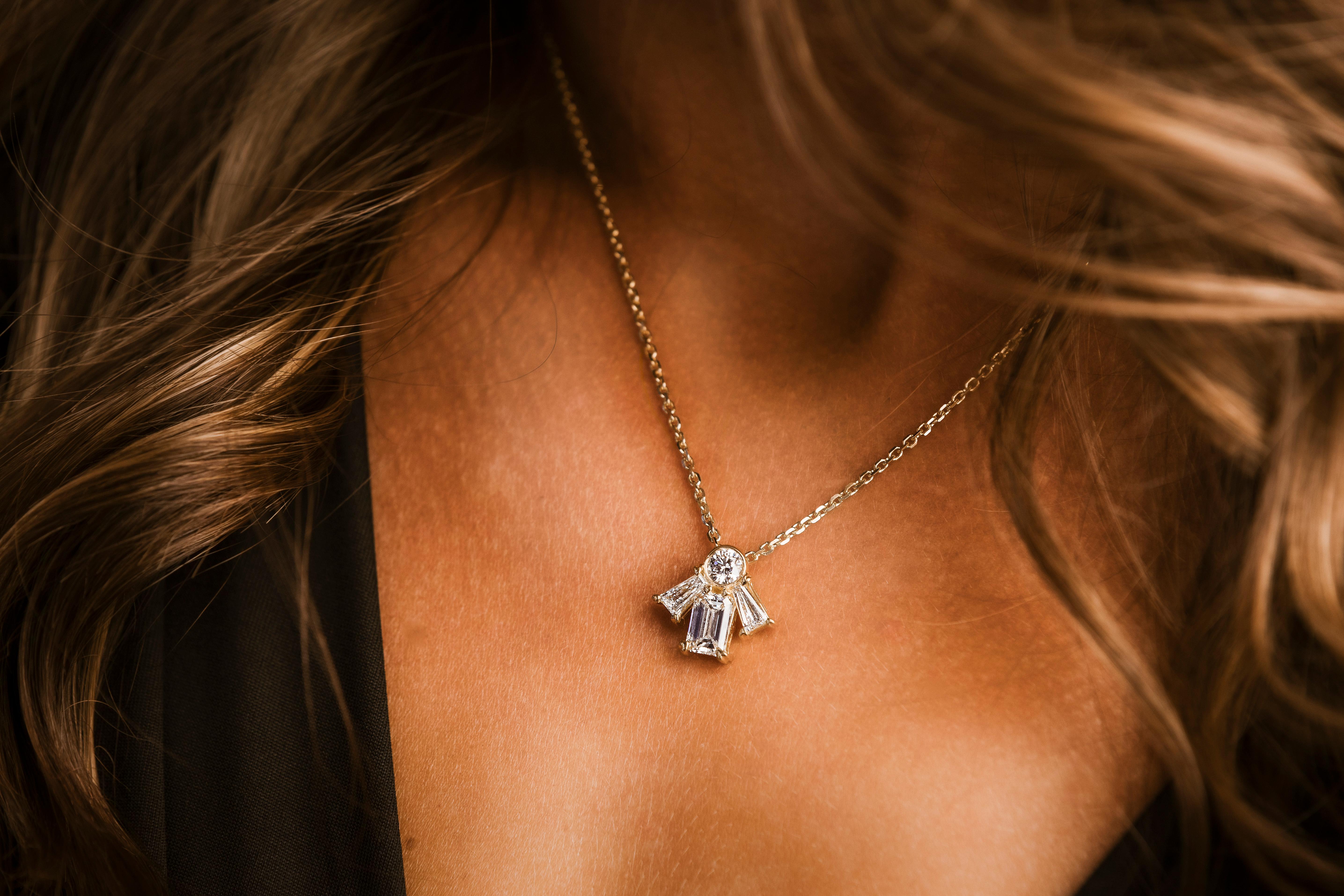 This stunning 18k yellow gold pendant necklace features a total of 2.53 carats of natural round, tapered baguette, and emerald cut diamonds. The diamonds are GIA certified with D color and Flawless clarity, ensuring exceptional brilliance and