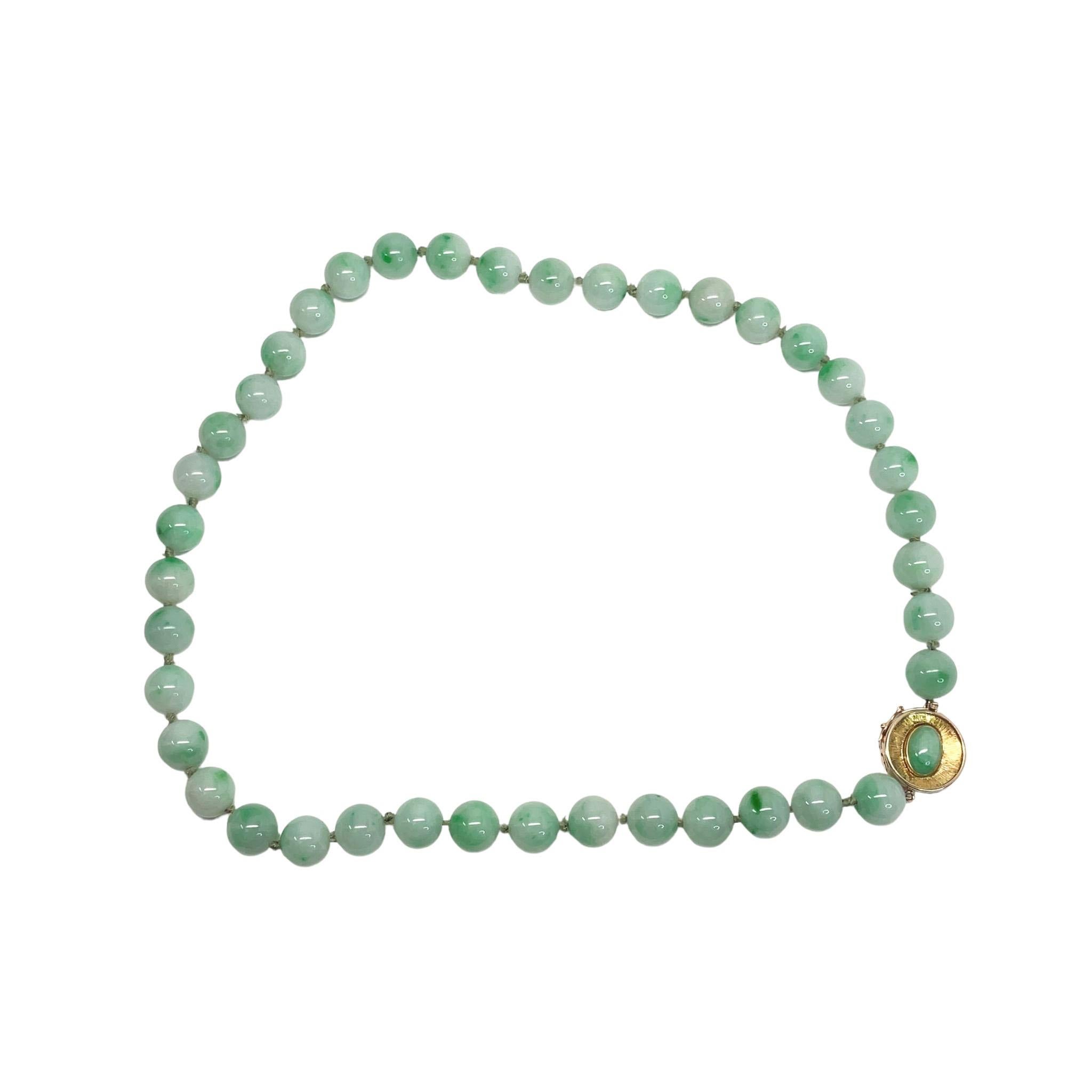 This is an absolutely stunning natural jade beaded necklace with a 14K yellow gold clasp. The cool green of this magnificent necklace is reminiscent of the color of the jungles of Southeast Asia. 

This necklace has been certified by the Gemological