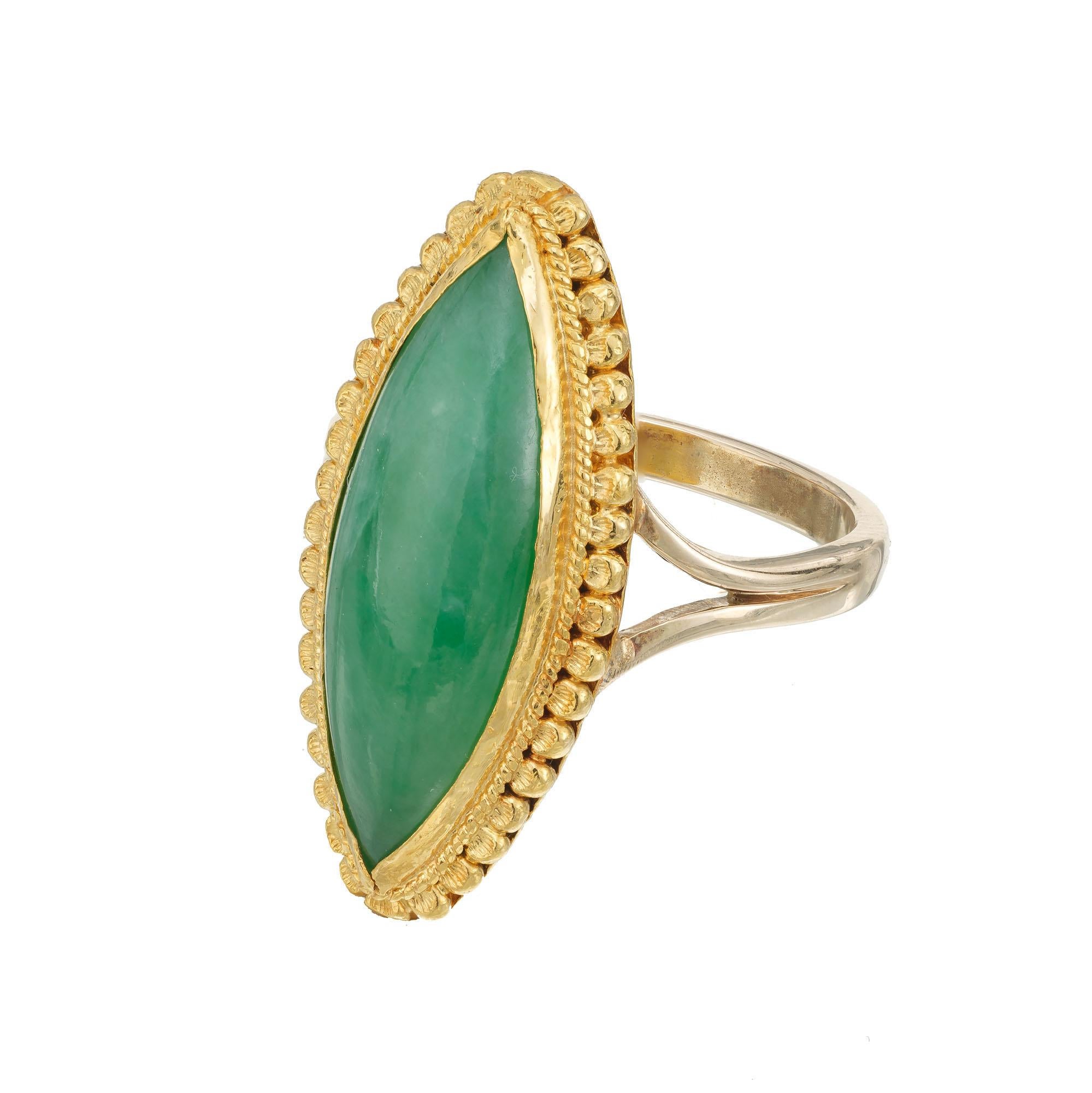 1970's Translucent bright green certified natural Jadeite Jade cocktail ring. GIA certified Marquise center stone The top is 24k gold with Oriental writing on the bottom under the stone. The shank is 14k gold. 

14k and 24k Yellow gold
One green