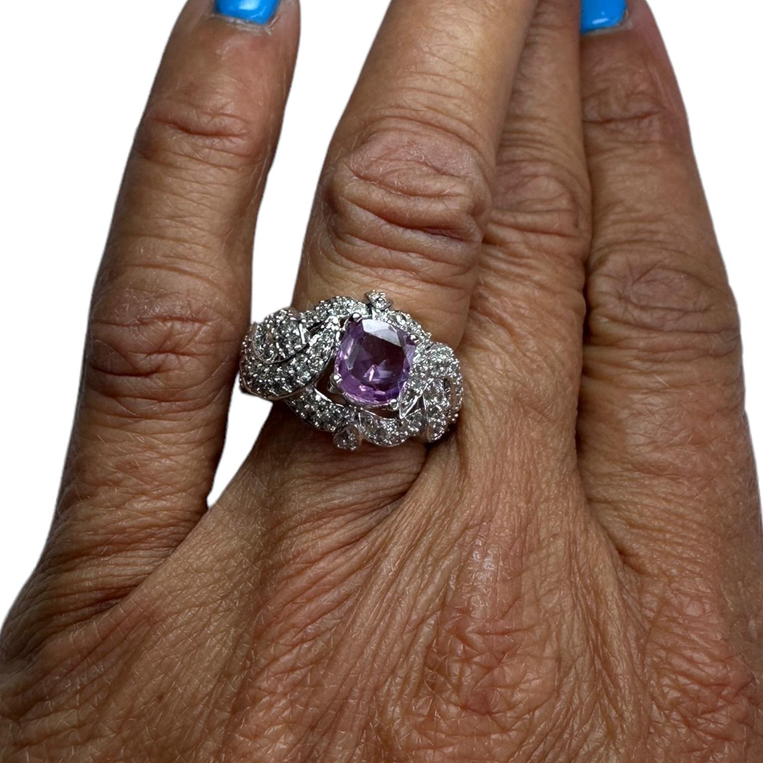 Elevate your style with this breathtaking 14K white gold solitaire ring with a natural pink sapphire centerpiece. The cushion cut 1.43-carat sapphire is surrounded by a pave diamond band, totaling .75 carats. This elegant 15mm dome-style ring is the