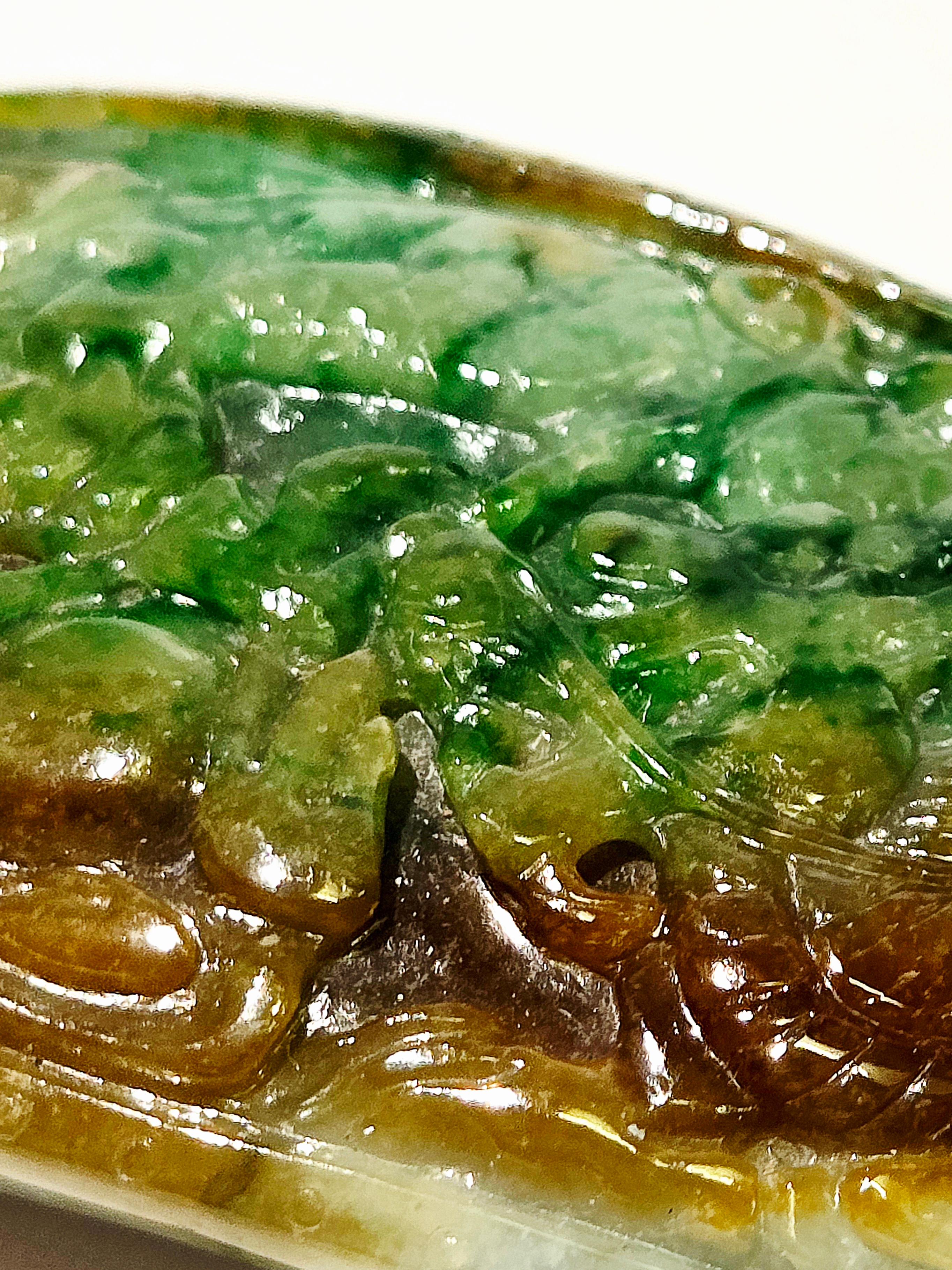 A natural jadeite jade ornament, suffused with rich brown, deep green, and warm honey tones. Finely carved in the form of a peaceful dragon expelling a dragon ball—an auspicious motif traditionally symbolizing protection, strength, and good fortune.