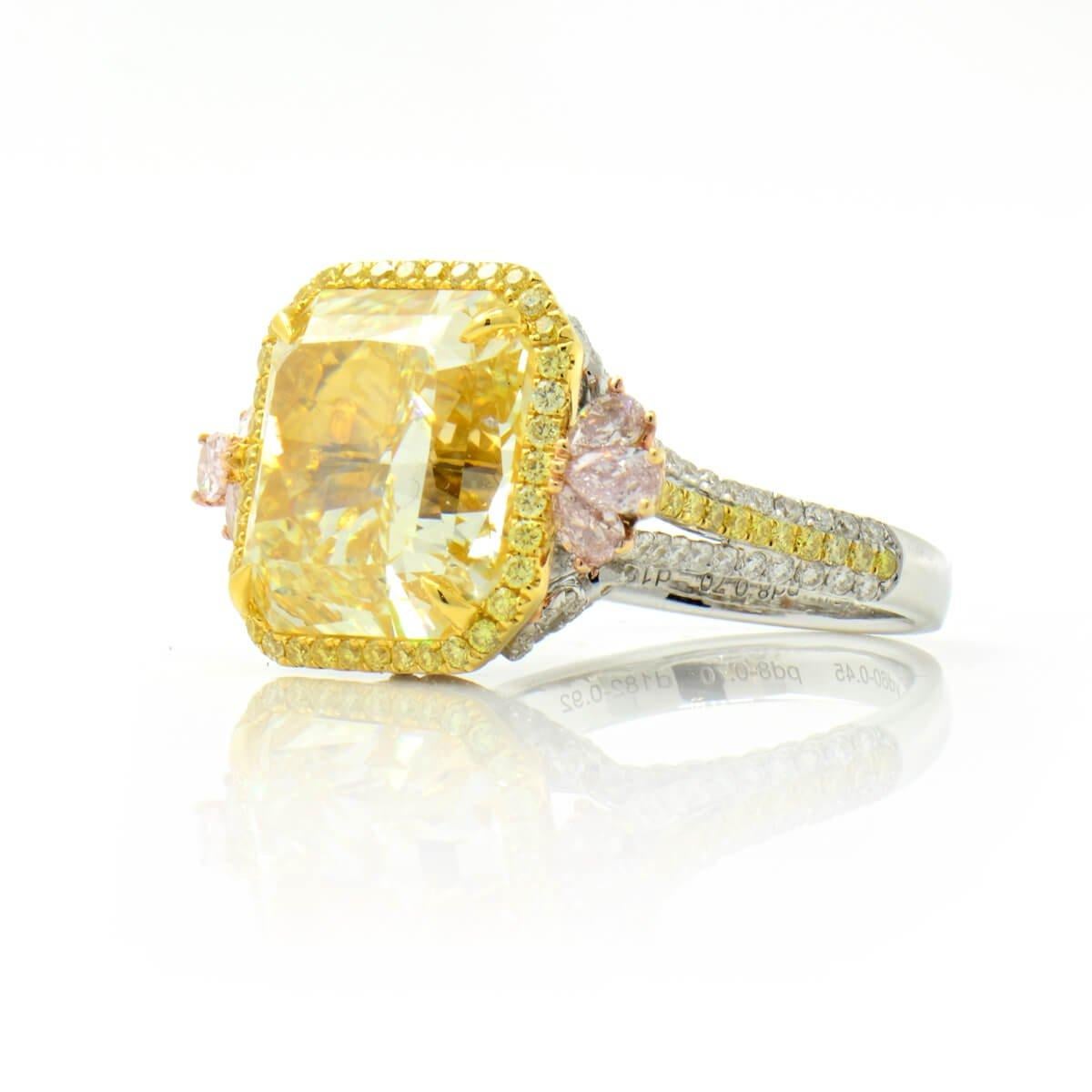 This once in a life time piece hosts one incredible 12.07 natural yellow diamond centre stone. It is stunningly compliment by smaller yellow stones surrounding it and pink stones either side, a variation of pink yellow and white diamonds around the