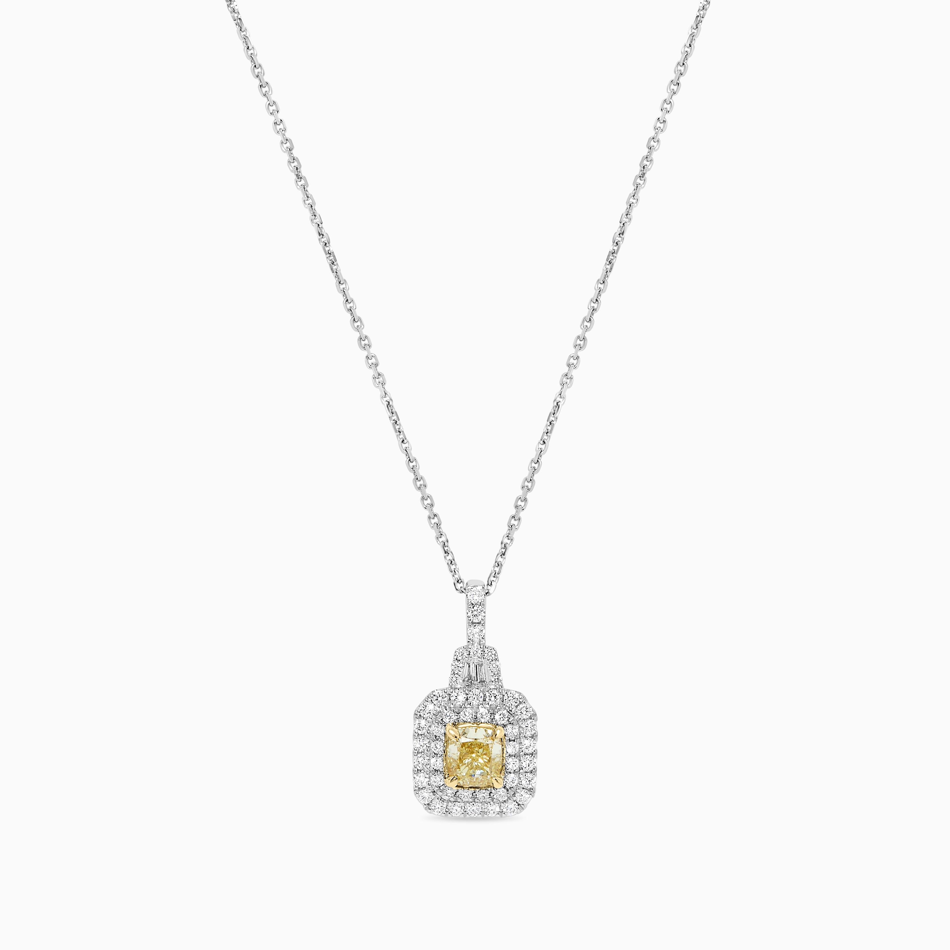 RareGemWorld's intriguing GIA certified diamond pendant. Mounted in a beautiful 18K Yellow and White Gold setting with a natural cushion cut yellow diamond. The yellow diamond is surrounded by natural baguette cut white diamonds and round natural