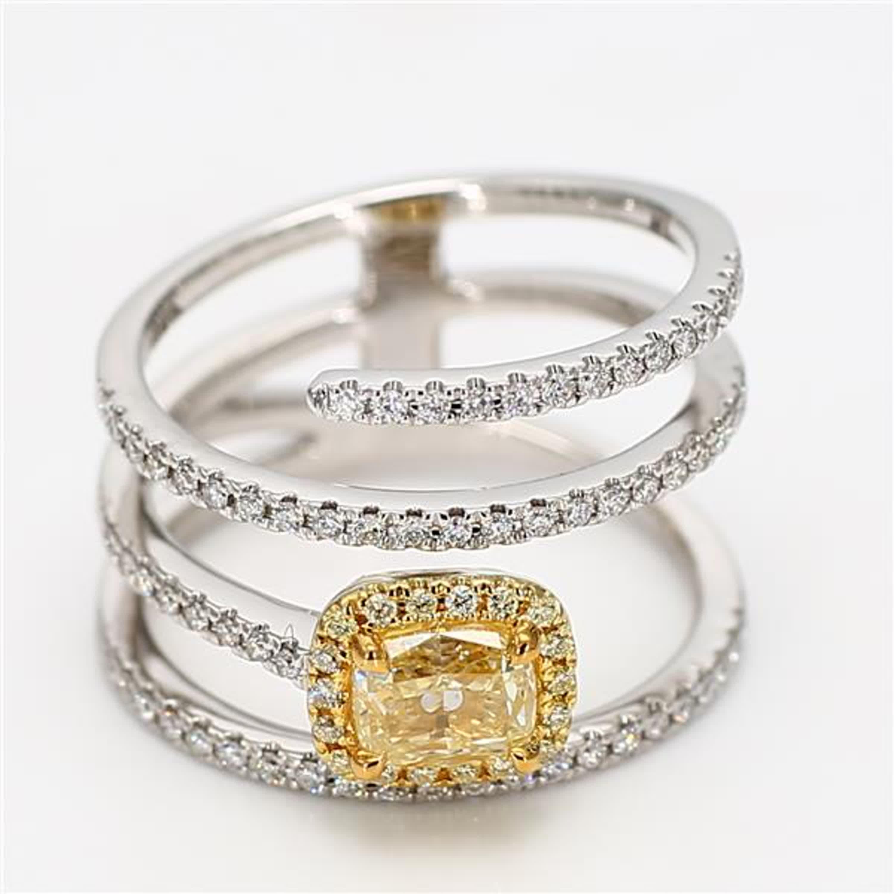 RareGemWorld's classic GIA certified diamond ring. Mounted in a beautiful 18K Yellow and White Gold setting with a natural cushion cut yellow diamond. The yellow diamond is surrounded by round natural white diamond melee and natural round yellow