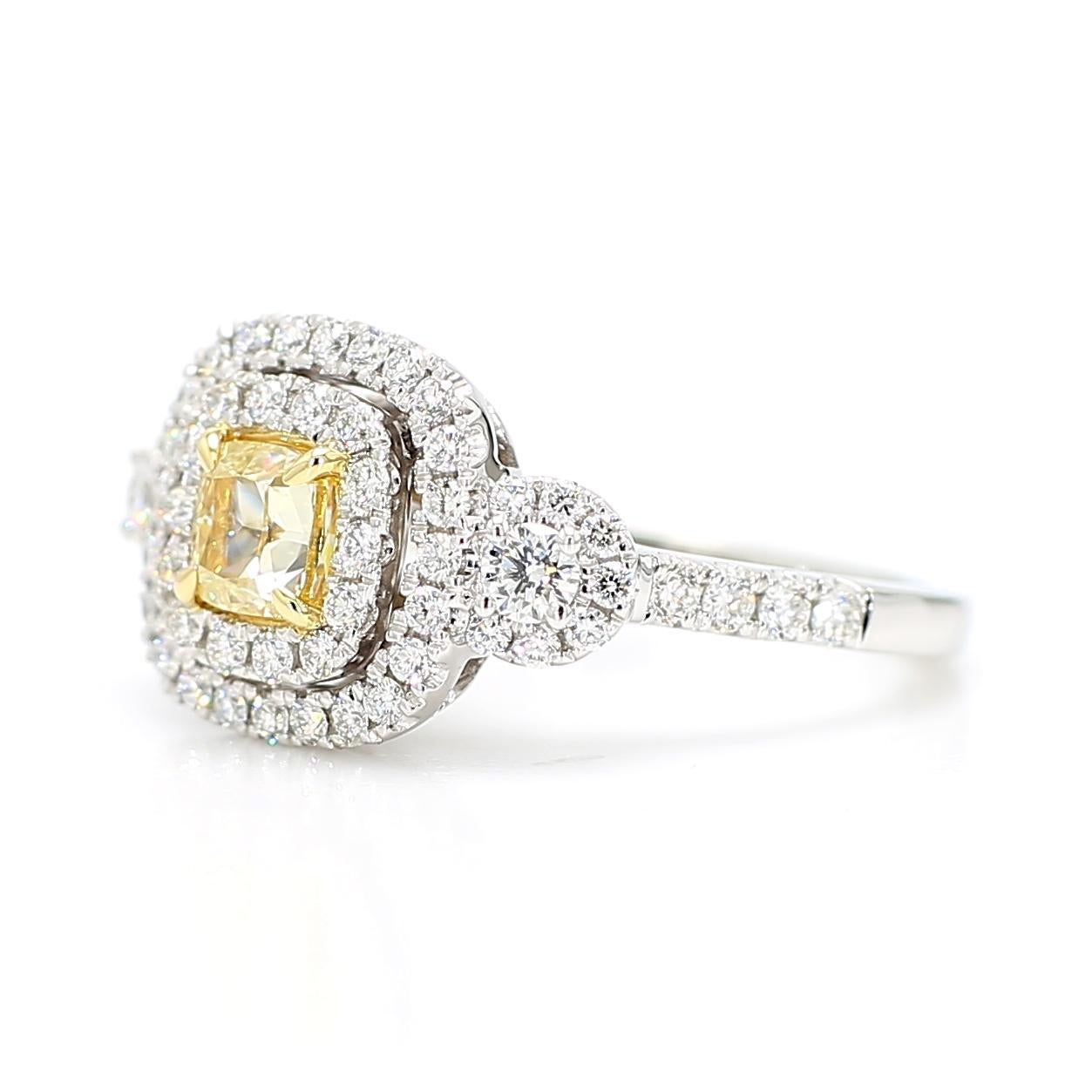 RareGemWorld's beautiful diamond ring. Mounted in a beautiful 18K Gold and platinum setting with a natural cushion cut yellow diamond. The yellow diamond is surrounded by round natural white diamond melee. This ring is guaranteed to impress and
